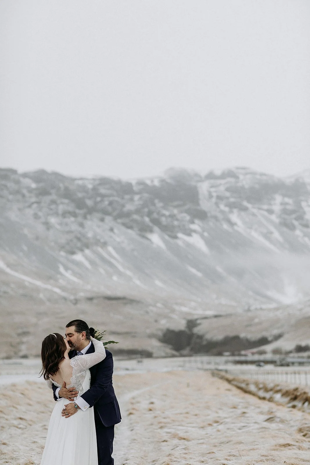 A Winter Iceland Elopement at Skógafoss (Skogafoss) and Glacier — couple in front of mountains