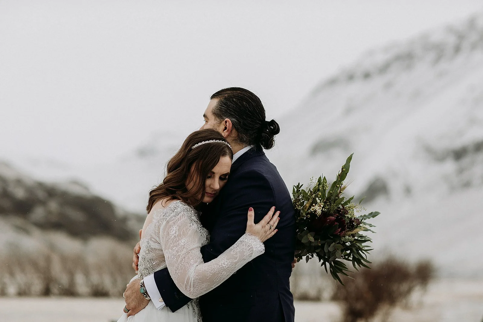 A Winter Iceland Elopement at Skógafoss (Skogafoss) and Glacier — couple in front of mountains