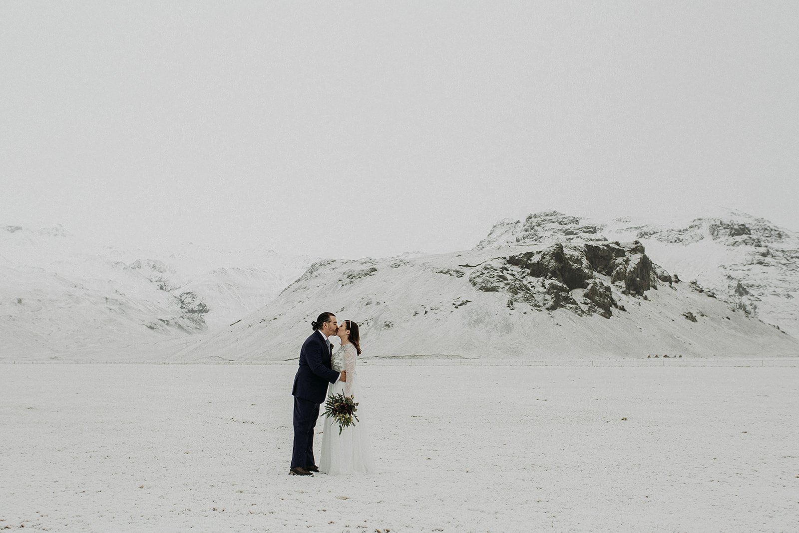 A Winter Iceland Elopement at Skógafoss (Skogafoss) and Glacier — couple in snowy field