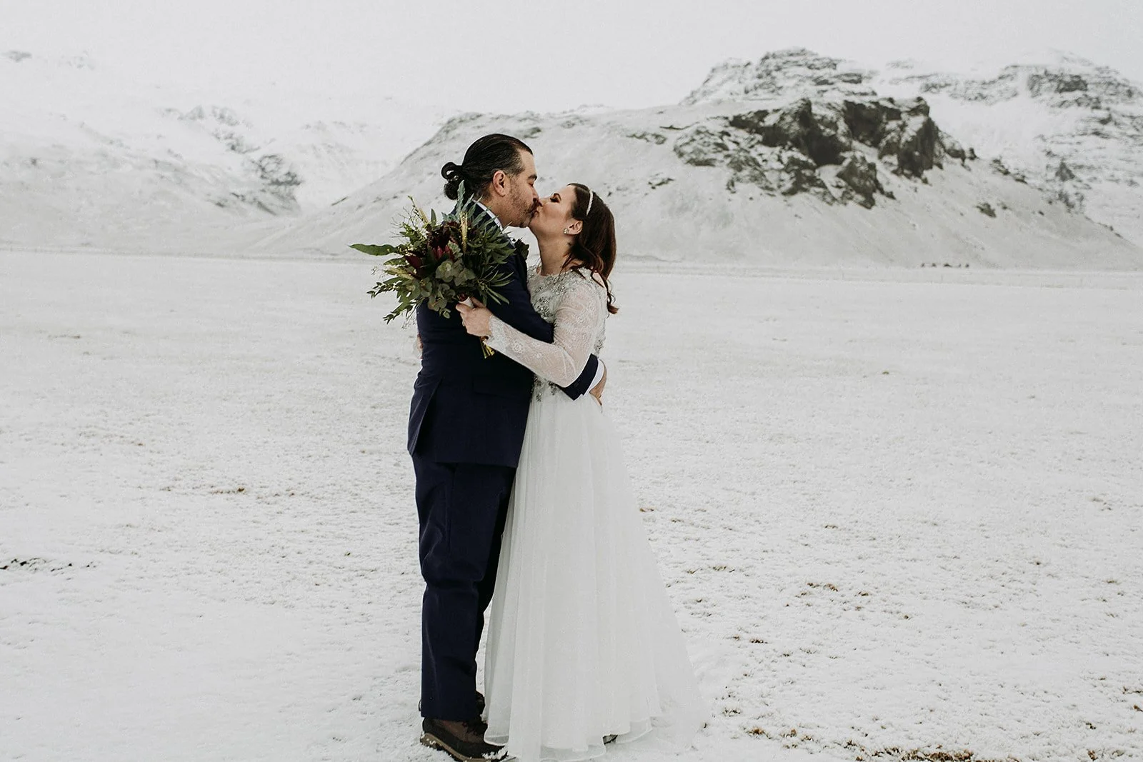 A Winter Iceland Elopement at Skógafoss (Skogafoss) and Glacier — couple in snowy field