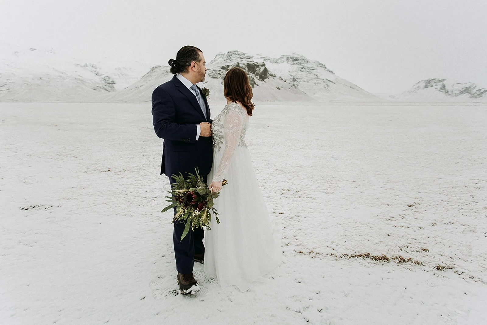 A Winter Iceland Elopement at Skógafoss (Skogafoss) and Glacier — couple in snowy field