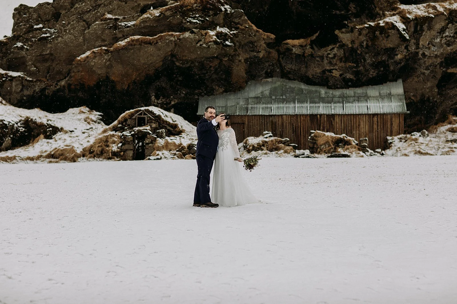 A Winter Iceland Elopement at Skógafoss (Skogafoss) and Glacier — couple in snowy field