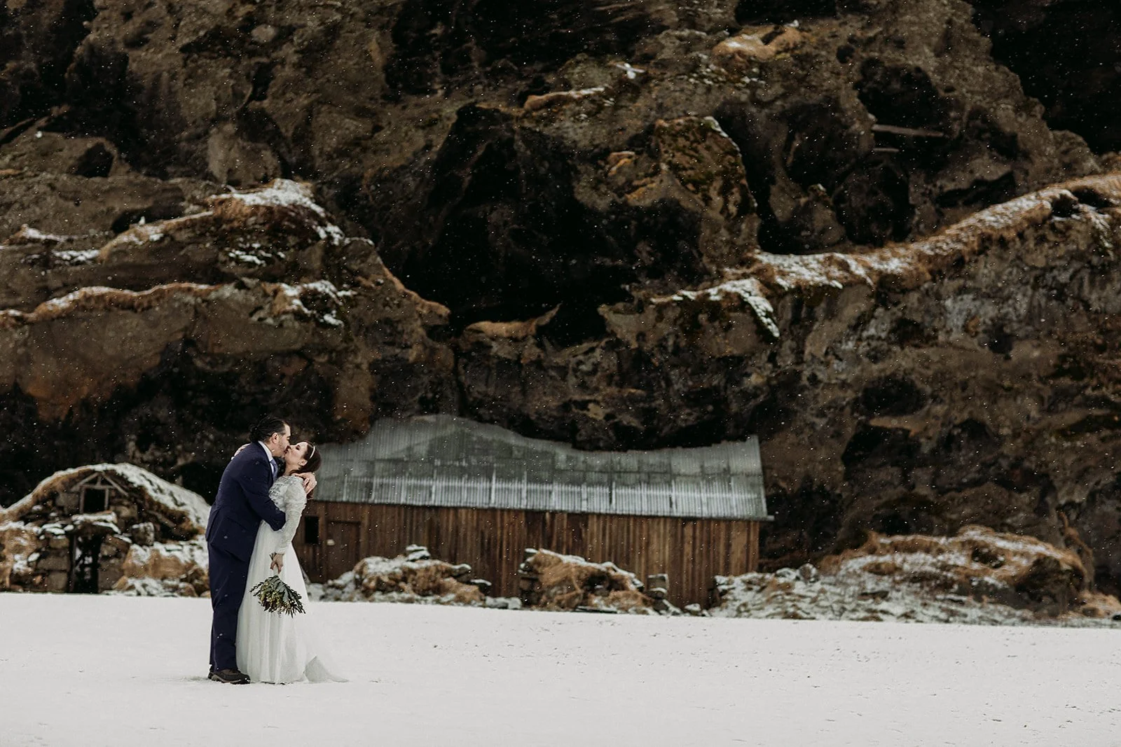 A Winter Iceland Elopement at Skógafoss (Skogafoss) and Glacier — couple in snowy field