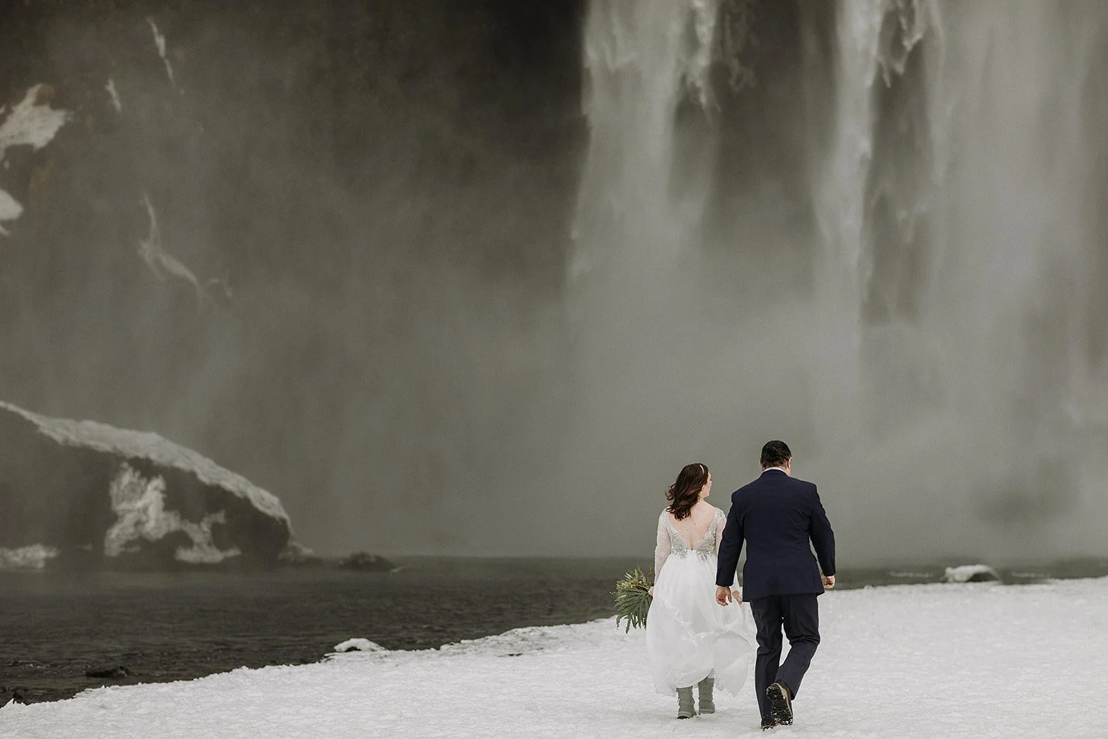 A Winter Iceland Elopement at Skógafoss (Skogafoss) and Glacier — couple at waterfall