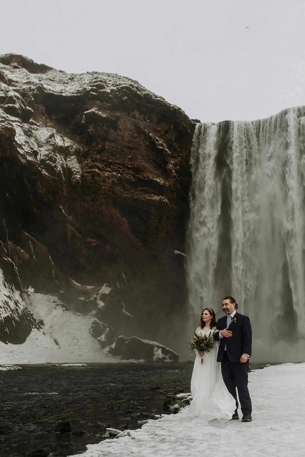 A Winter Iceland Elopement at Skógafoss (Skogafoss) and Glacier — couple at waterfall