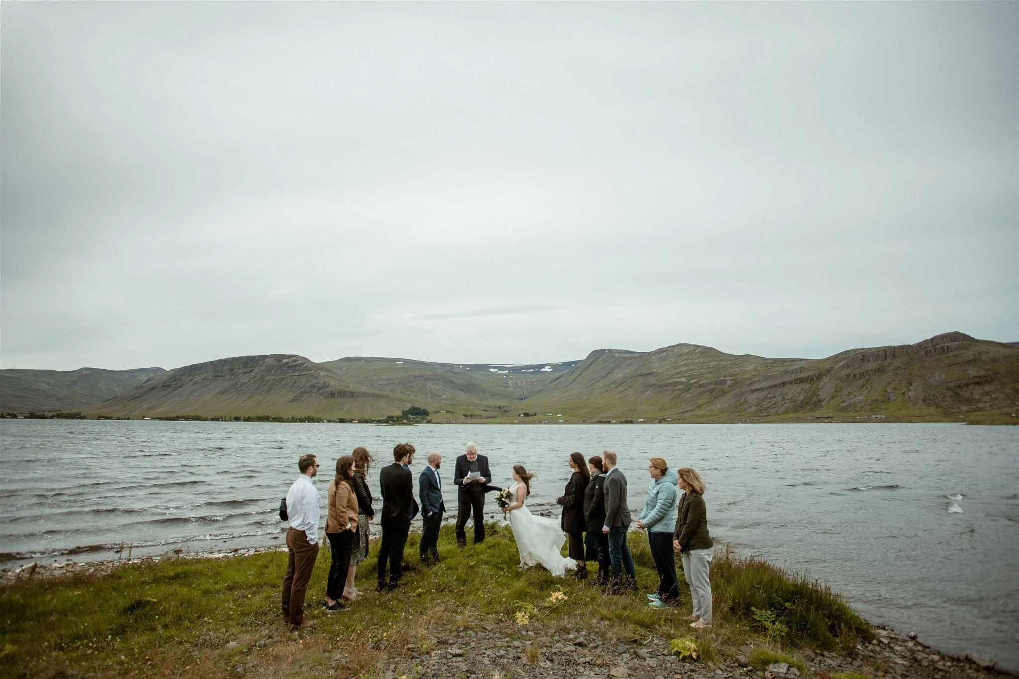  A Private Lake Iceland Elopement Starting in Reykjavík with Guests — at the private ceremony on a private lake with their guests surrounding them 