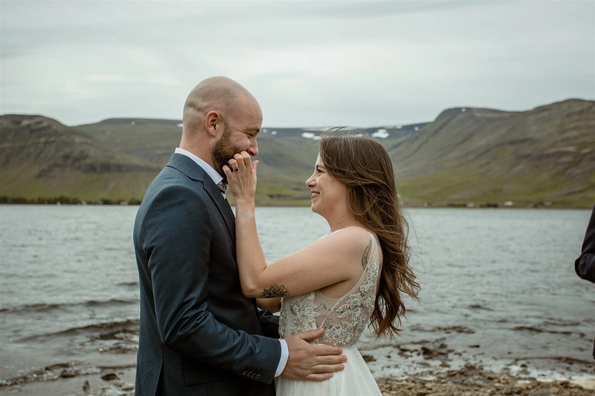  A Private Lake Iceland Elopement Starting in Reykjavík with Guests — couple first kiss at ceremony  