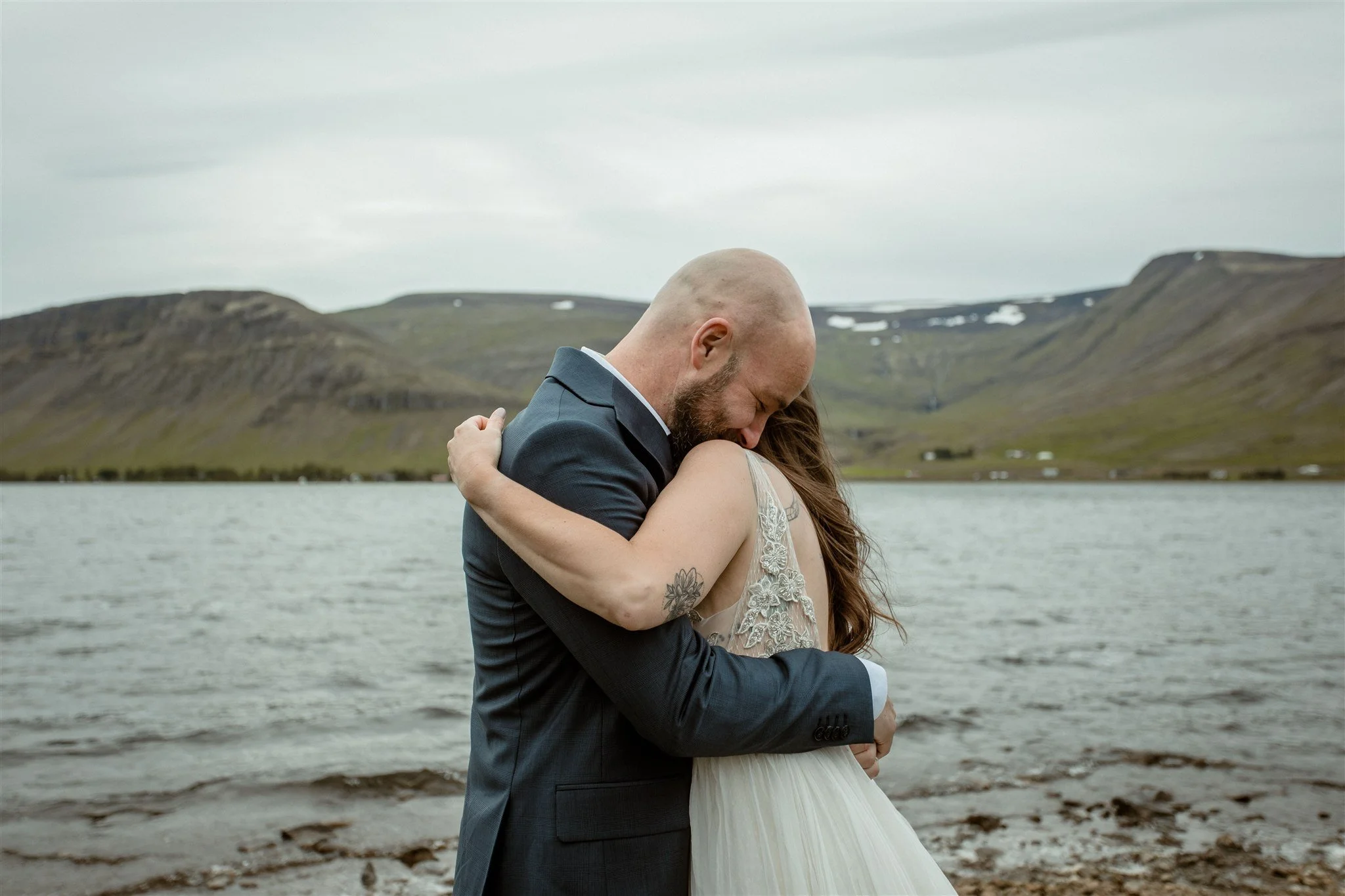  A Private Lake Iceland Elopement Starting in Reykjavík with Guests — couple first kiss at ceremony  