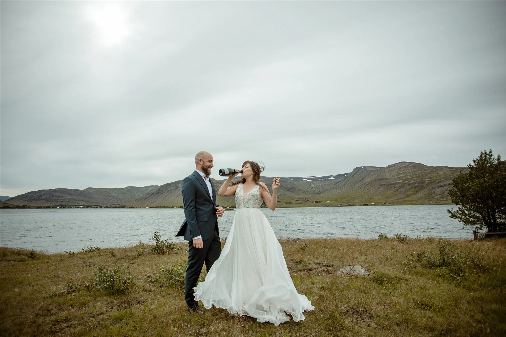  A Private Lake Iceland Elopement Starting in Reykjavík with Guests — couple after ceremony popping champagne 
