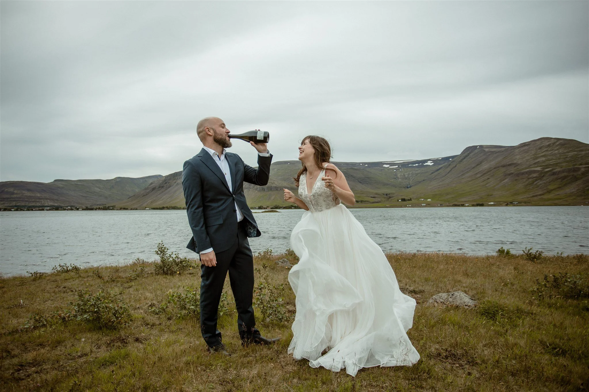  A Private Lake Iceland Elopement Starting in Reykjavík with Guests — couple after ceremony popping champagne 