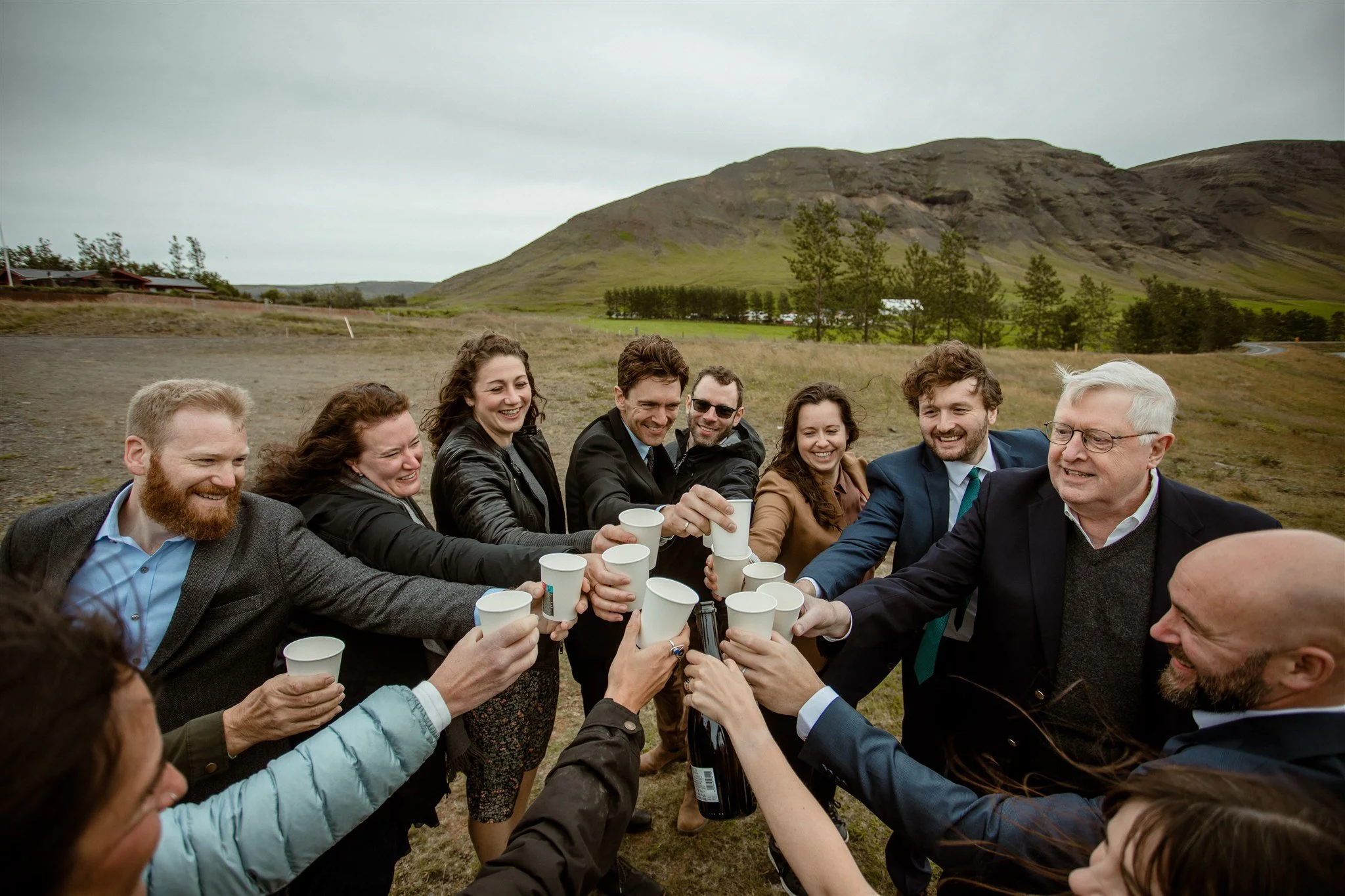  A Private Lake Iceland Elopement Starting in Reykjavík with Guests — couple after ceremony popping champagne 