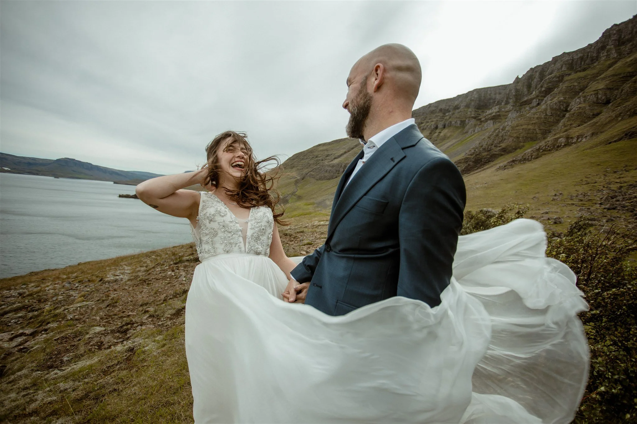  A Private Lake Iceland Elopement Starting in Reykjavík with Guests by Iceland elopement photographer &amp; planner Steph Zakas — couple on an adventure for elopement photos at a fjord in the wind 