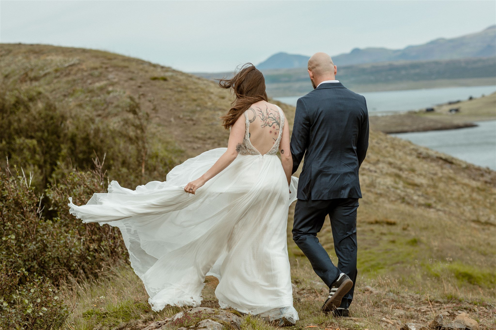 A Private Lake Iceland Elopement Starting in Reykjavík with Guests by Iceland elopement photographer &amp; planner Steph Zakas — couple on an adventure for elopement photos at a fjord in the wind 