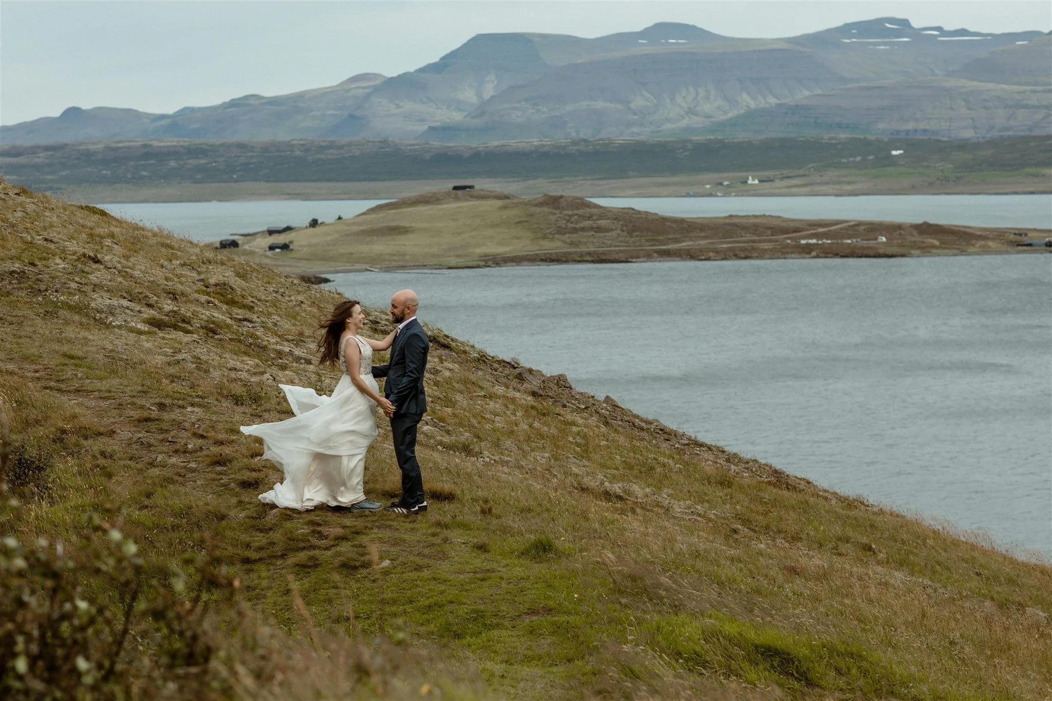  A Private Lake Iceland Elopement Starting in Reykjavík with Guests by Iceland elopement photographer &amp; planner Steph Zakas — couple on an adventure for elopement photos at a fjord in the wind 