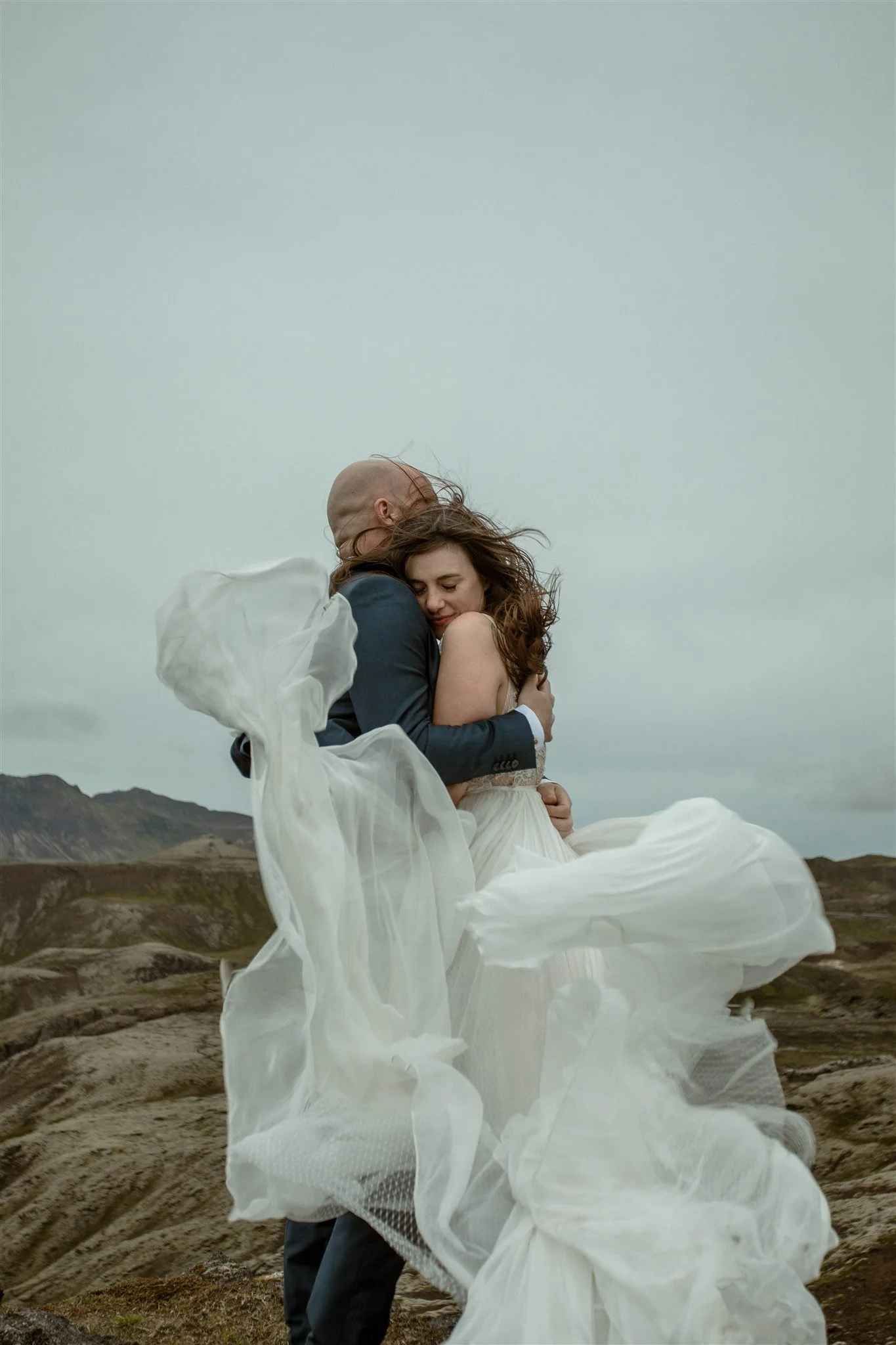 private Iceland elopement on top of a mountain with wind blown dress.