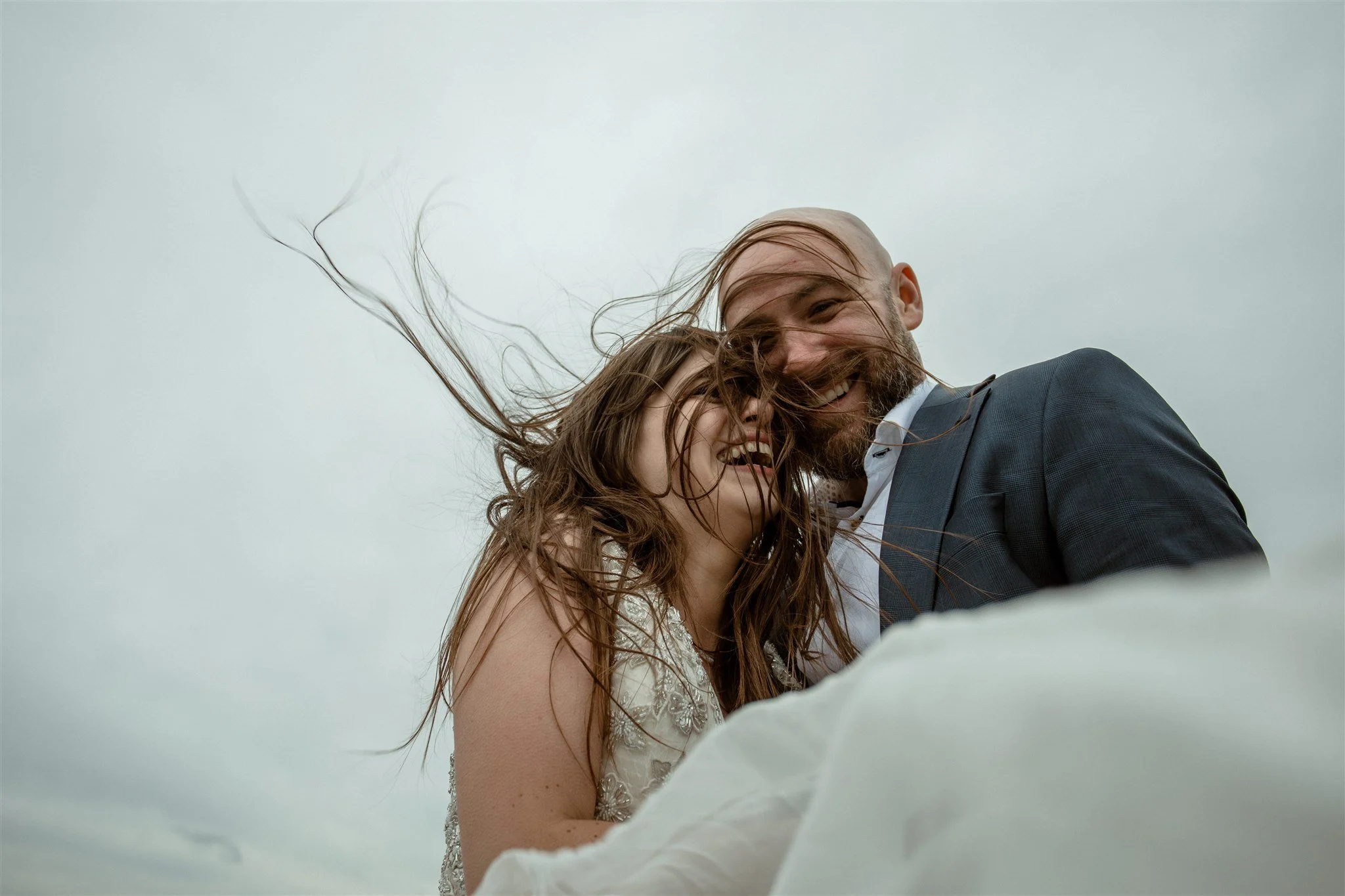  A Private Lake Iceland Elopement Starting in Reykjavík with Guests by Iceland elopement photographer &amp; planner Steph Zakas — couple on an adventure for elopement photos at a volcanic area with wind 