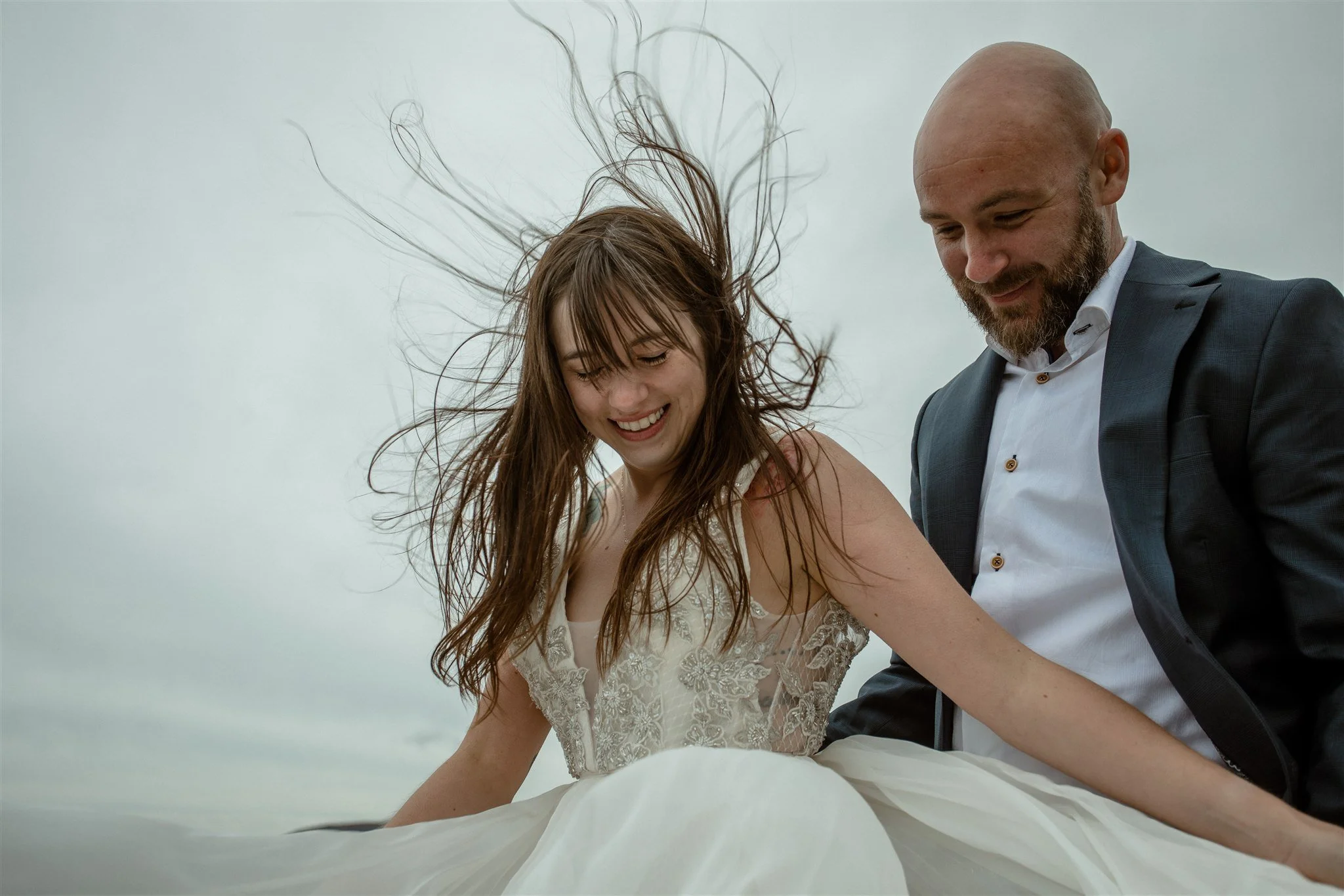  A Private Lake Iceland Elopement Starting in Reykjavík with Guests by Iceland elopement photographer &amp; planner Steph Zakas — couple on an adventure for elopement photos at a volcanic area with wind 
