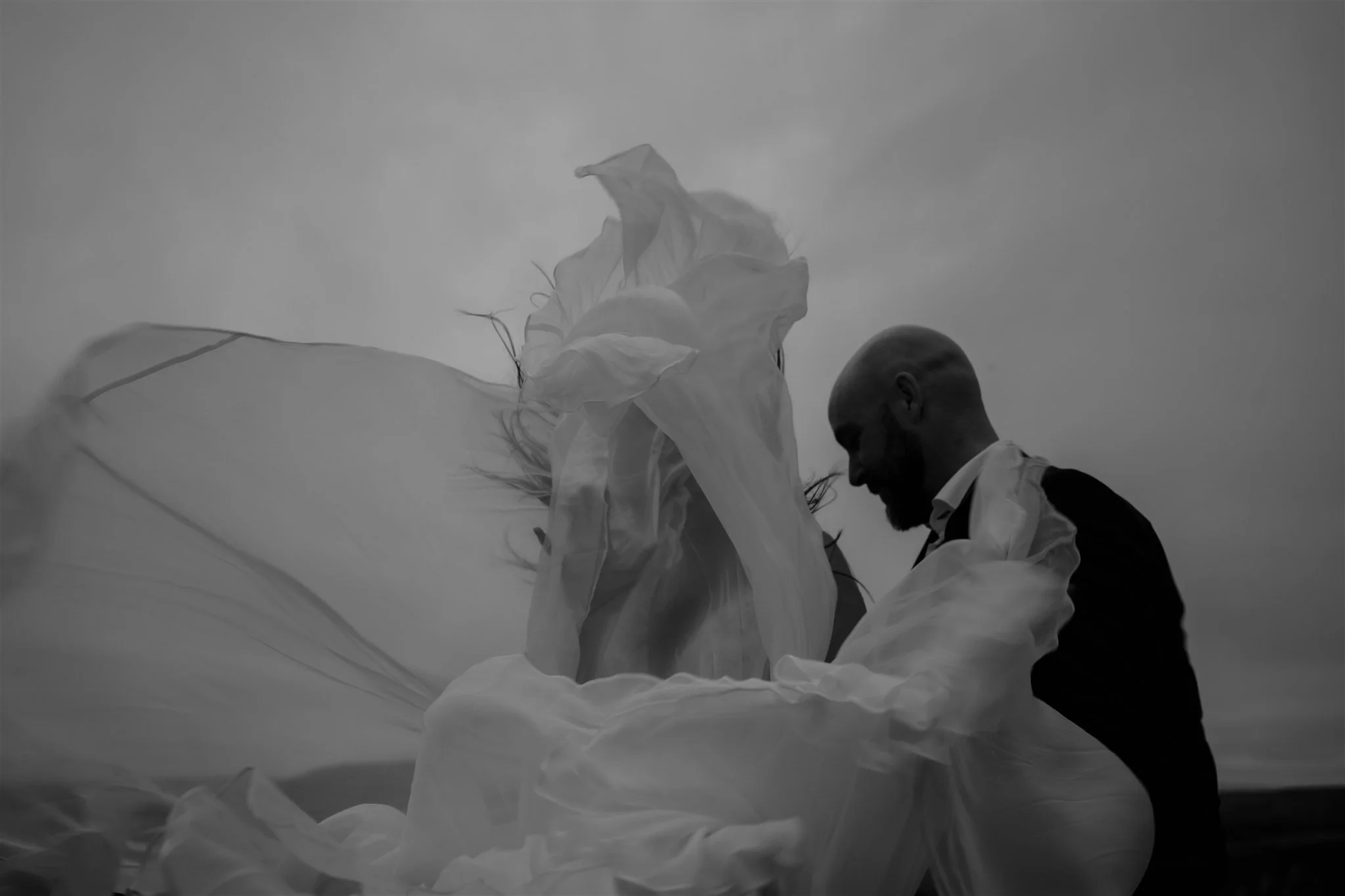  A Private Lake Iceland Elopement Starting in Reykjavík with Guests by Iceland elopement photographer &amp; planner Steph Zakas — couple on an adventure for elopement photos at a volcanic area with wind 