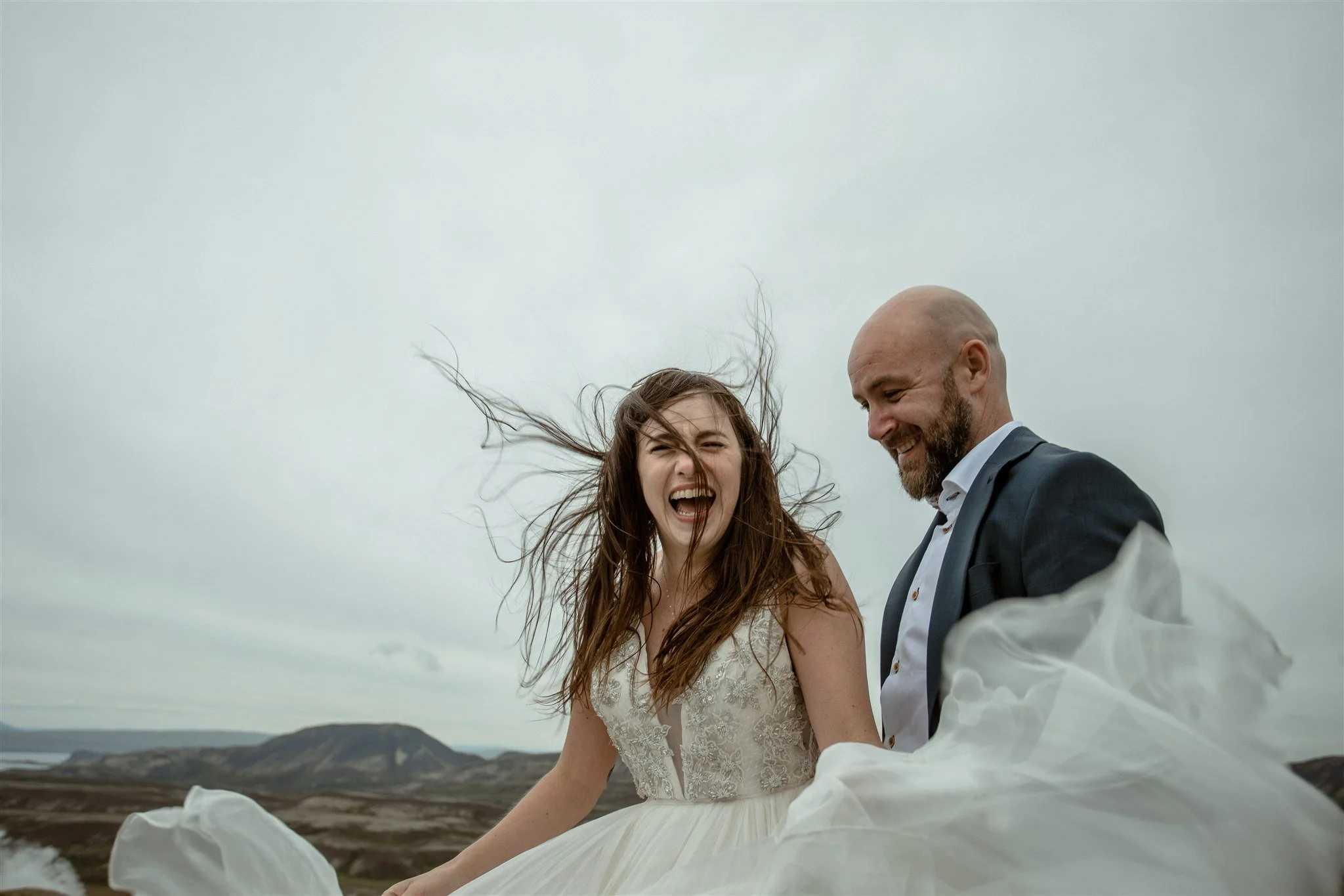 private iceland elopement in the wind with bride laughing by iceland elopement planner Steph zakas