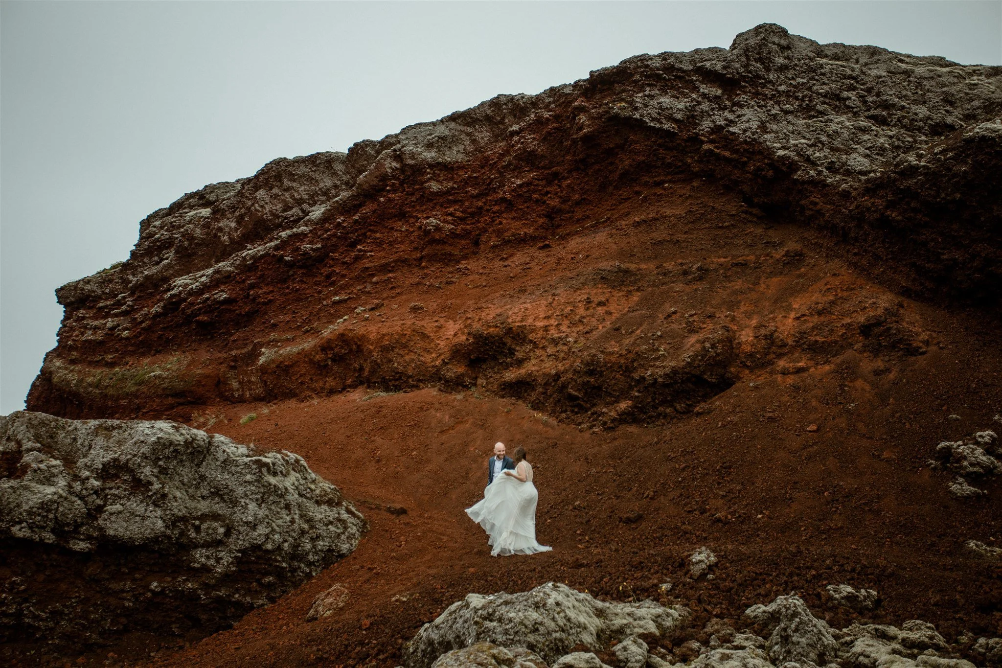  A Private Lake Iceland Elopement Starting in Reykjavík with Guests by Iceland elopement photographer &amp; planner Steph Zakas — couple on an adventure for elopement photos at a volcanic red area  