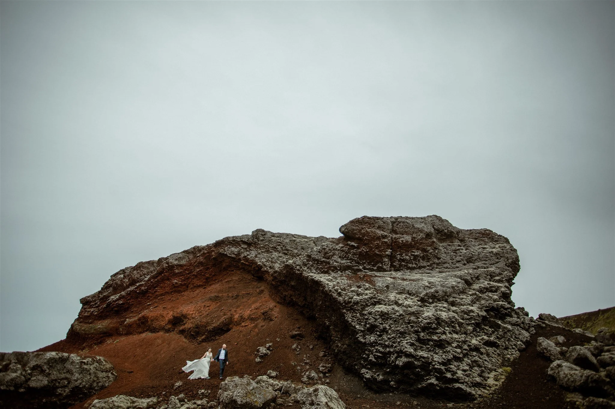  A Private Lake Iceland Elopement Starting in Reykjavík with Guests by Iceland elopement photographer &amp; planner Steph Zakas — couple on an adventure for elopement photos at a volcanic red area  