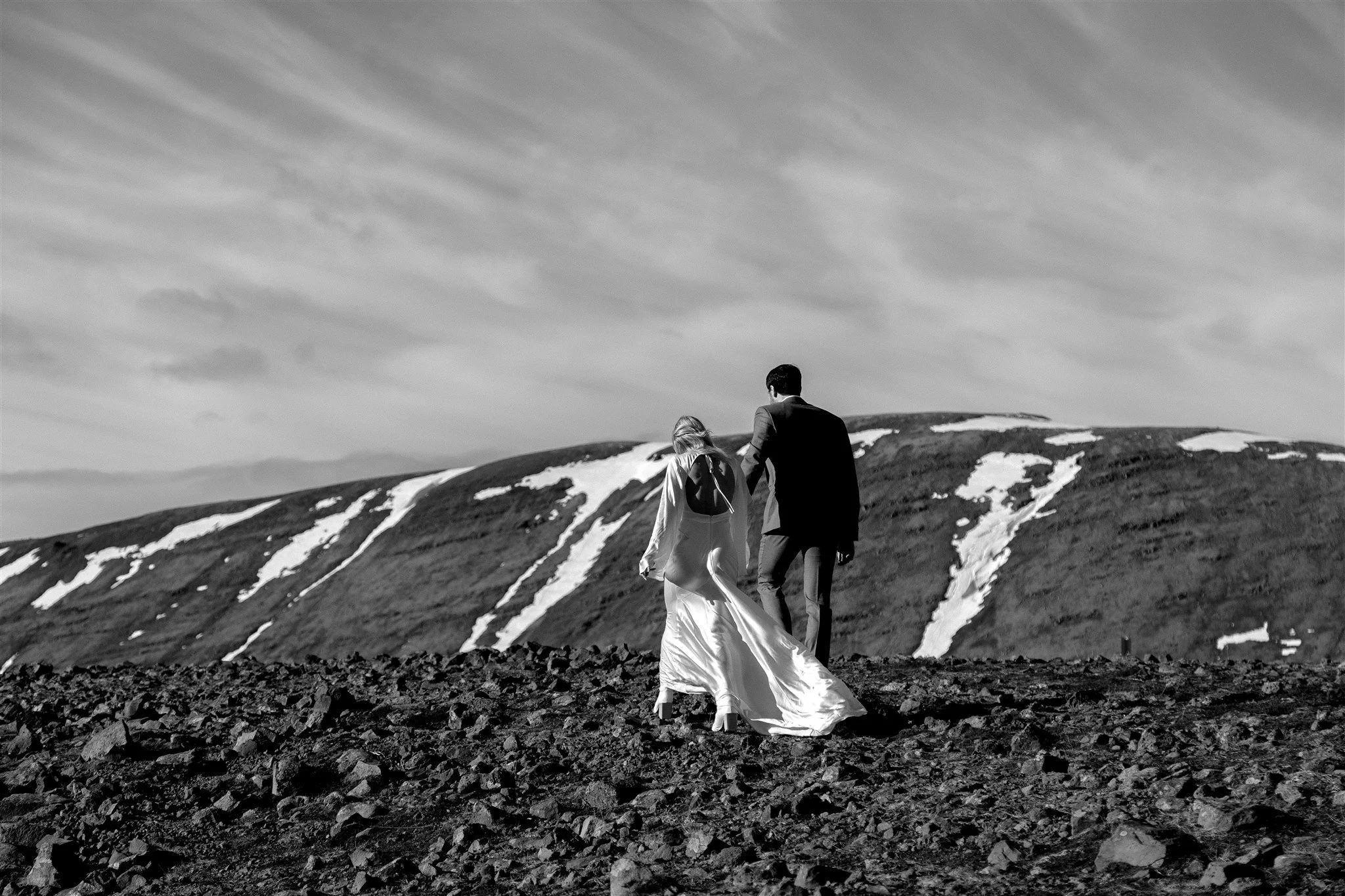 Lord of the Rings Inspired Iceland Engagement Photoshoot at waterfall — couple walking by mountains