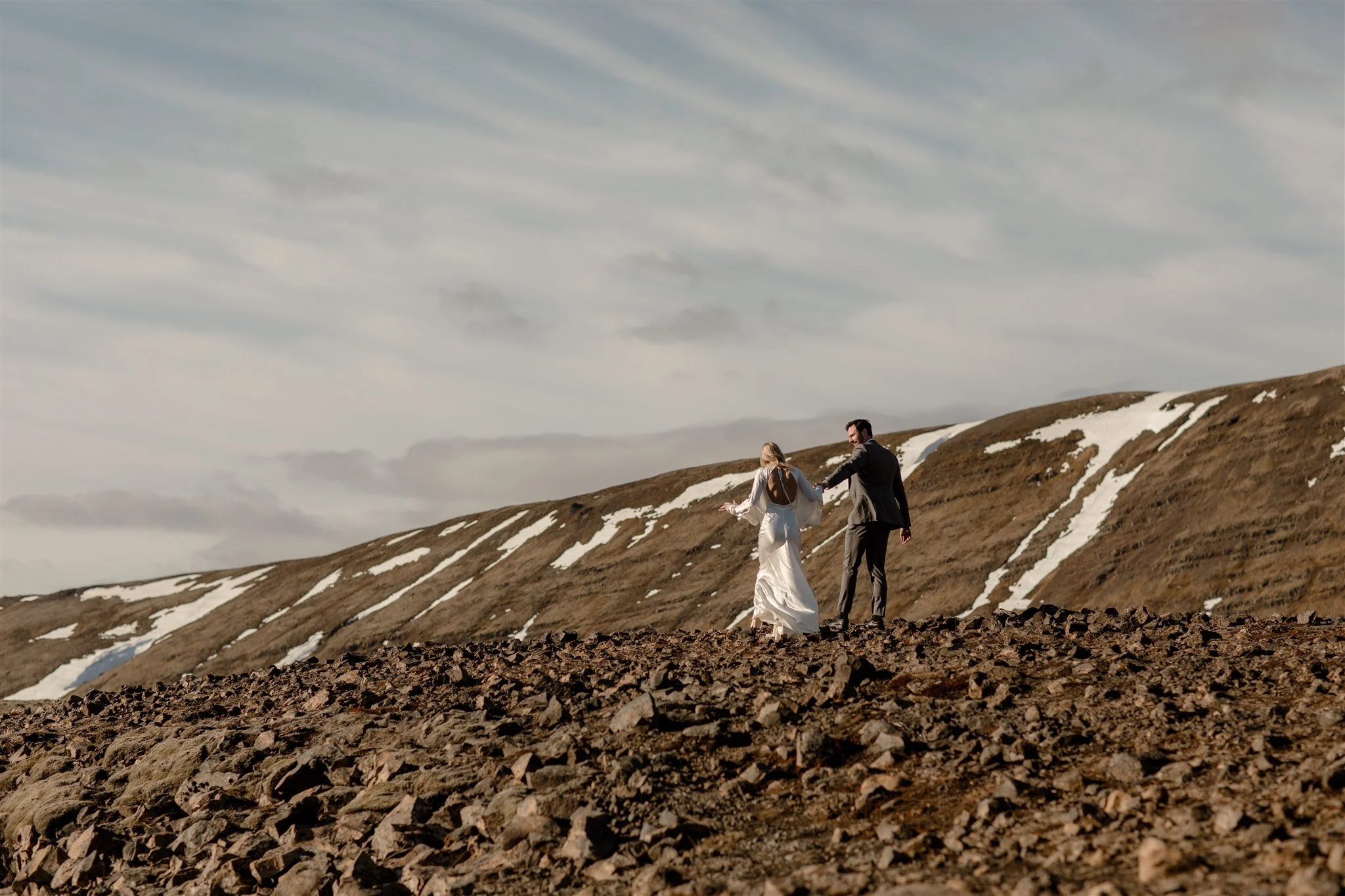 Lord of the Rings Inspired Iceland Engagement Photoshoot at waterfall — couple walking by mountains