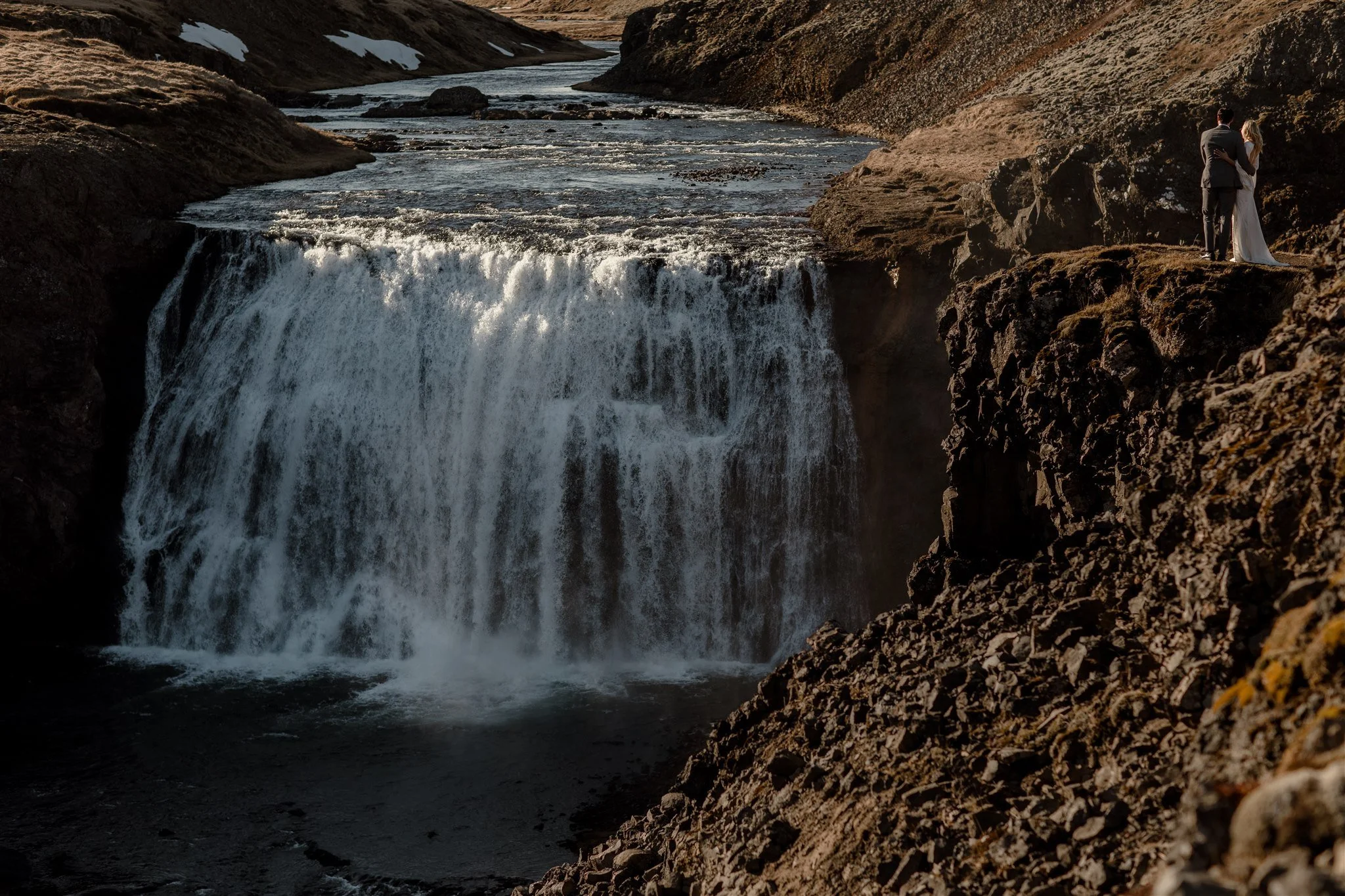 Lord of the Rings Inspired Iceland Engagement Photoshoot at waterfall — couple walking by mountains