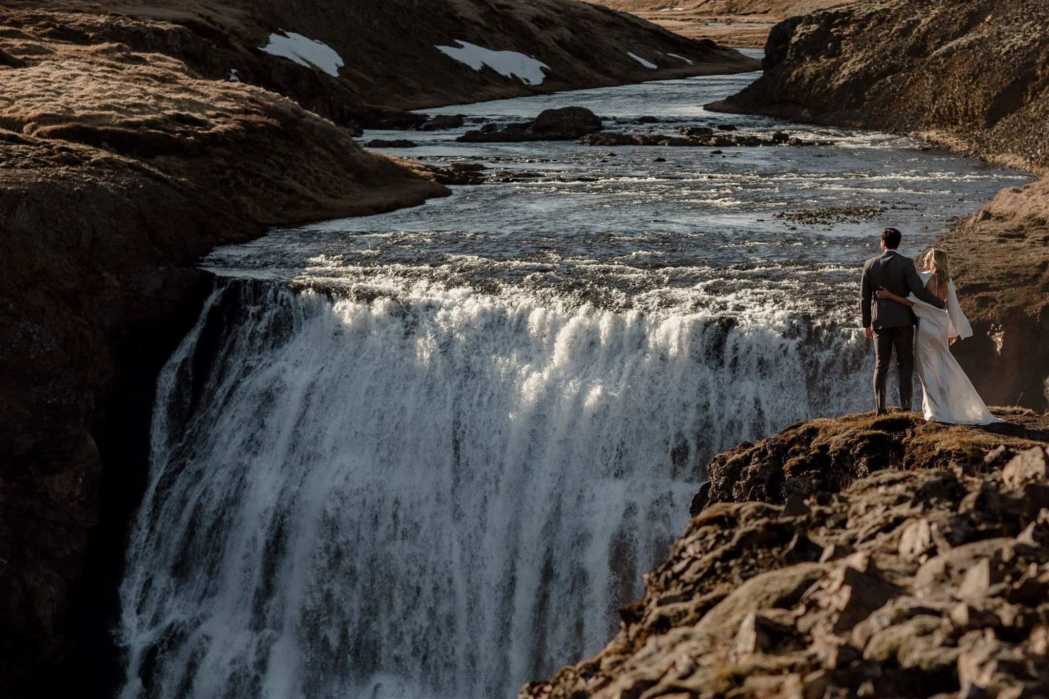 Lord of the Rings Inspired Iceland Engagement Photoshoot at waterfall — couple walking by mountains