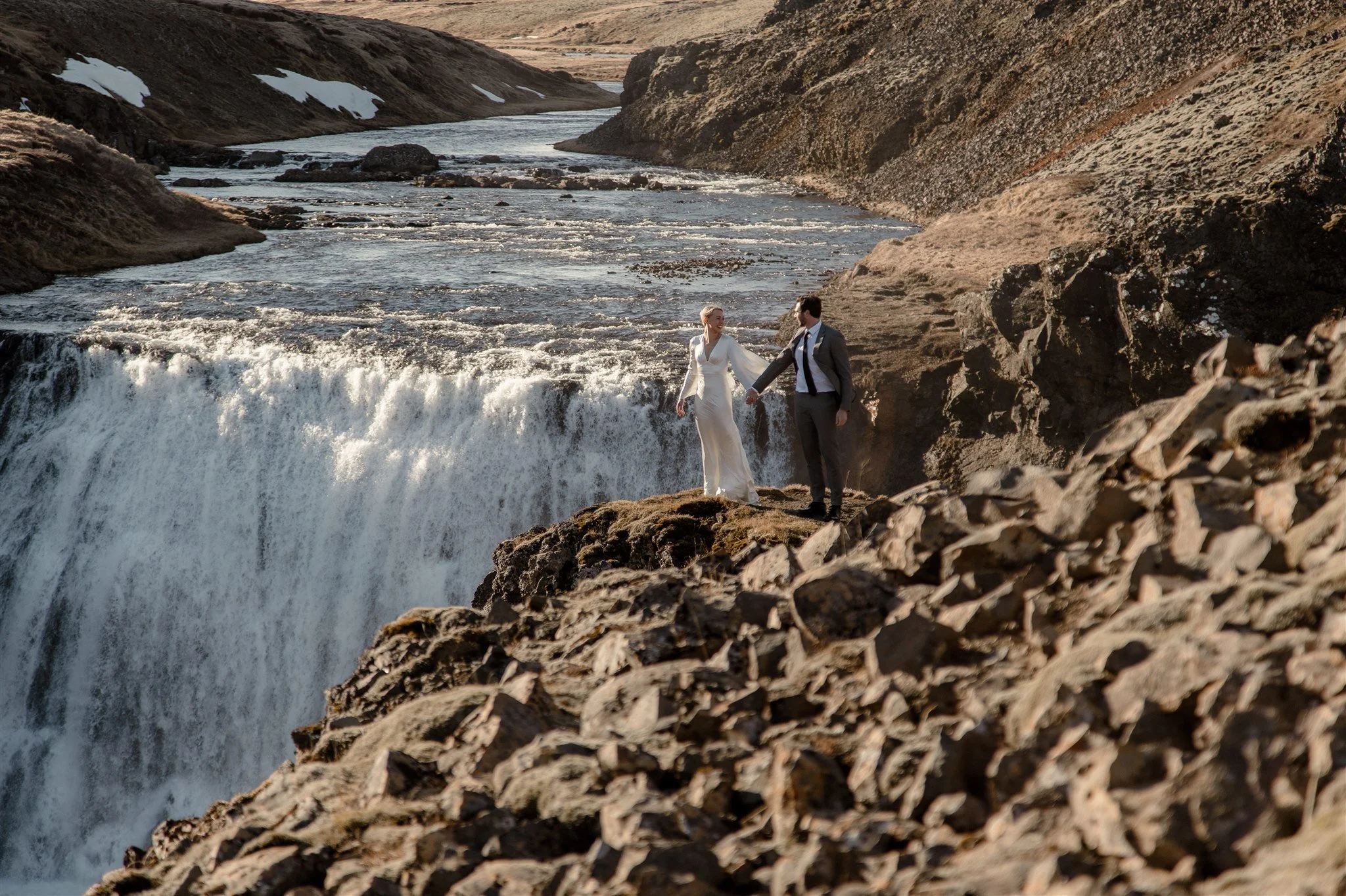 Lord of the Rings Inspired Iceland Engagement Photoshoot at waterfall — couple walking by mountains
