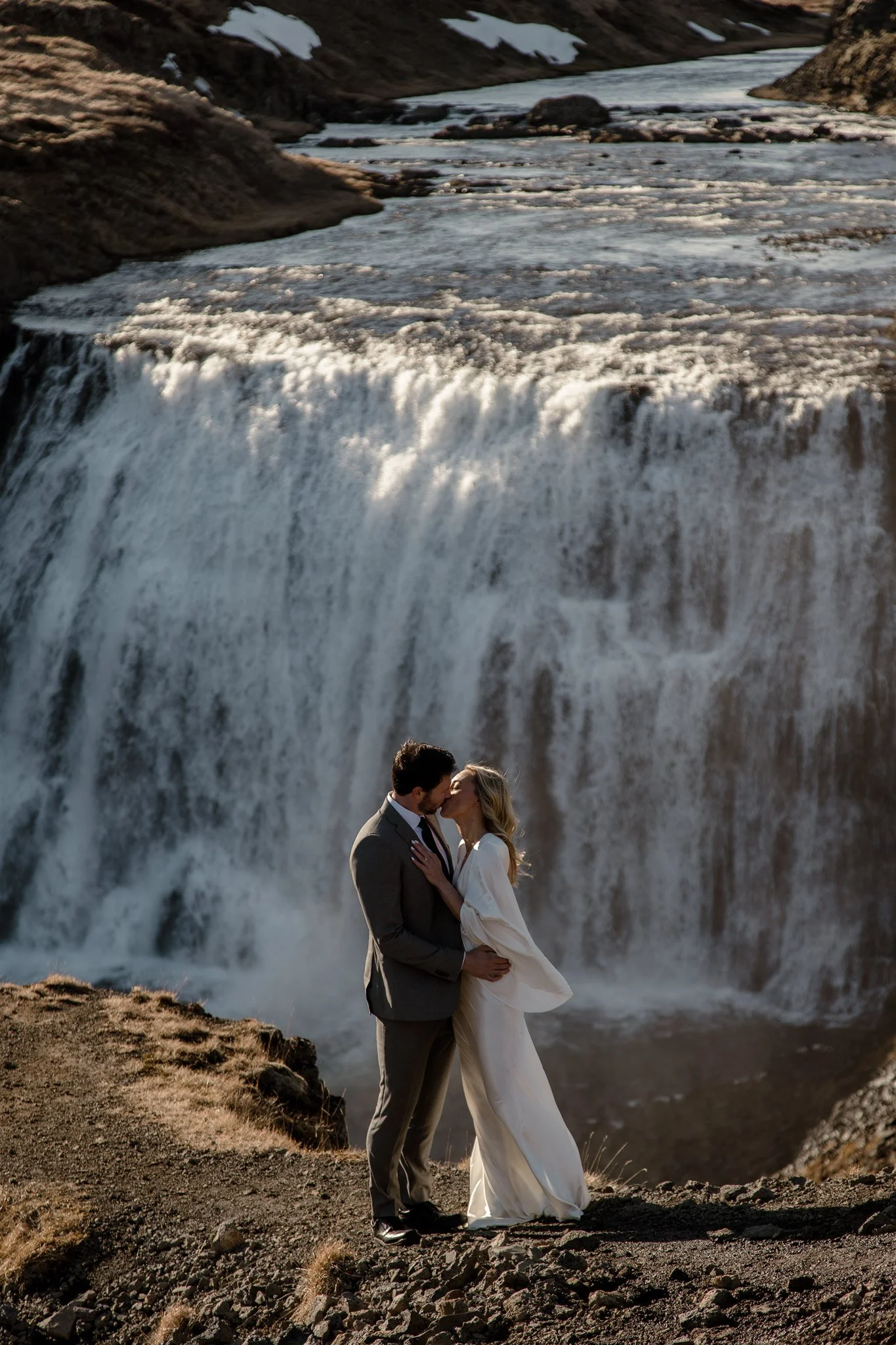 Lord of the Rings Inspired Iceland Engagement Photoshoot at waterfall — couple holding each other with Arwen inspired dress