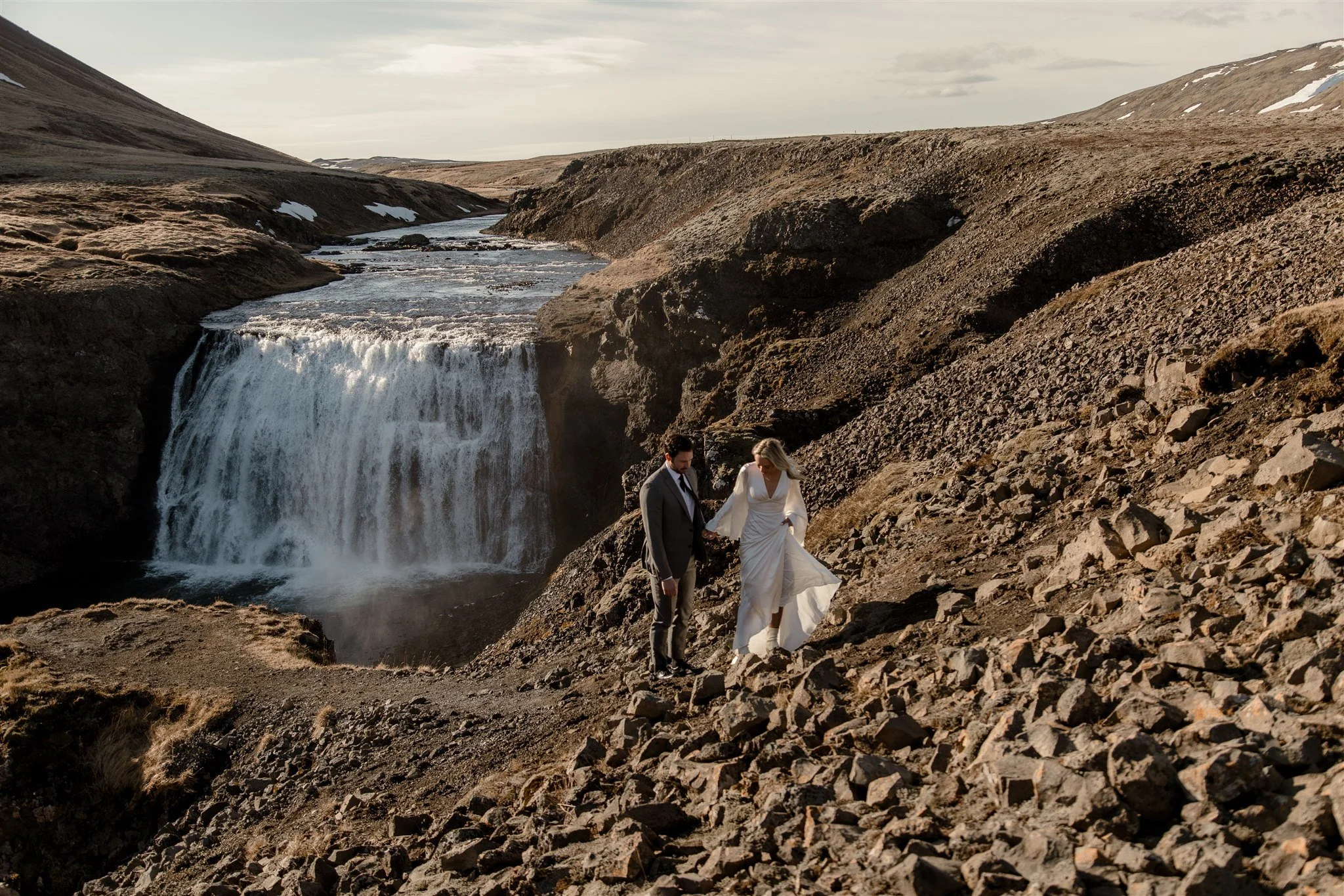 Lord of the Rings Inspired Iceland Engagement Photoshoot at waterfall — couple holding each other with Arwen inspired dress