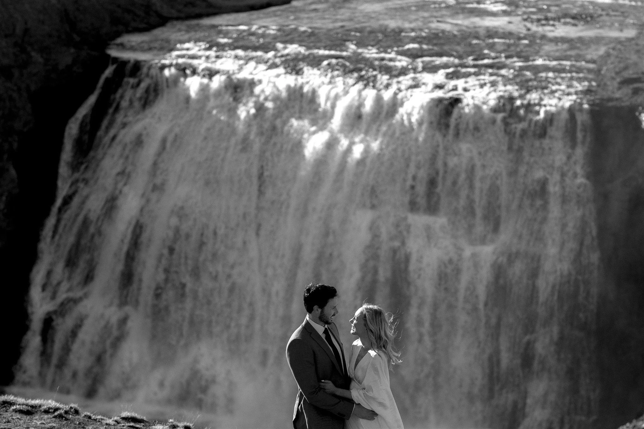 Lord of the Rings Inspired Iceland Engagement Photoshoot at waterfall — couple walking with Arwen inspired dress
