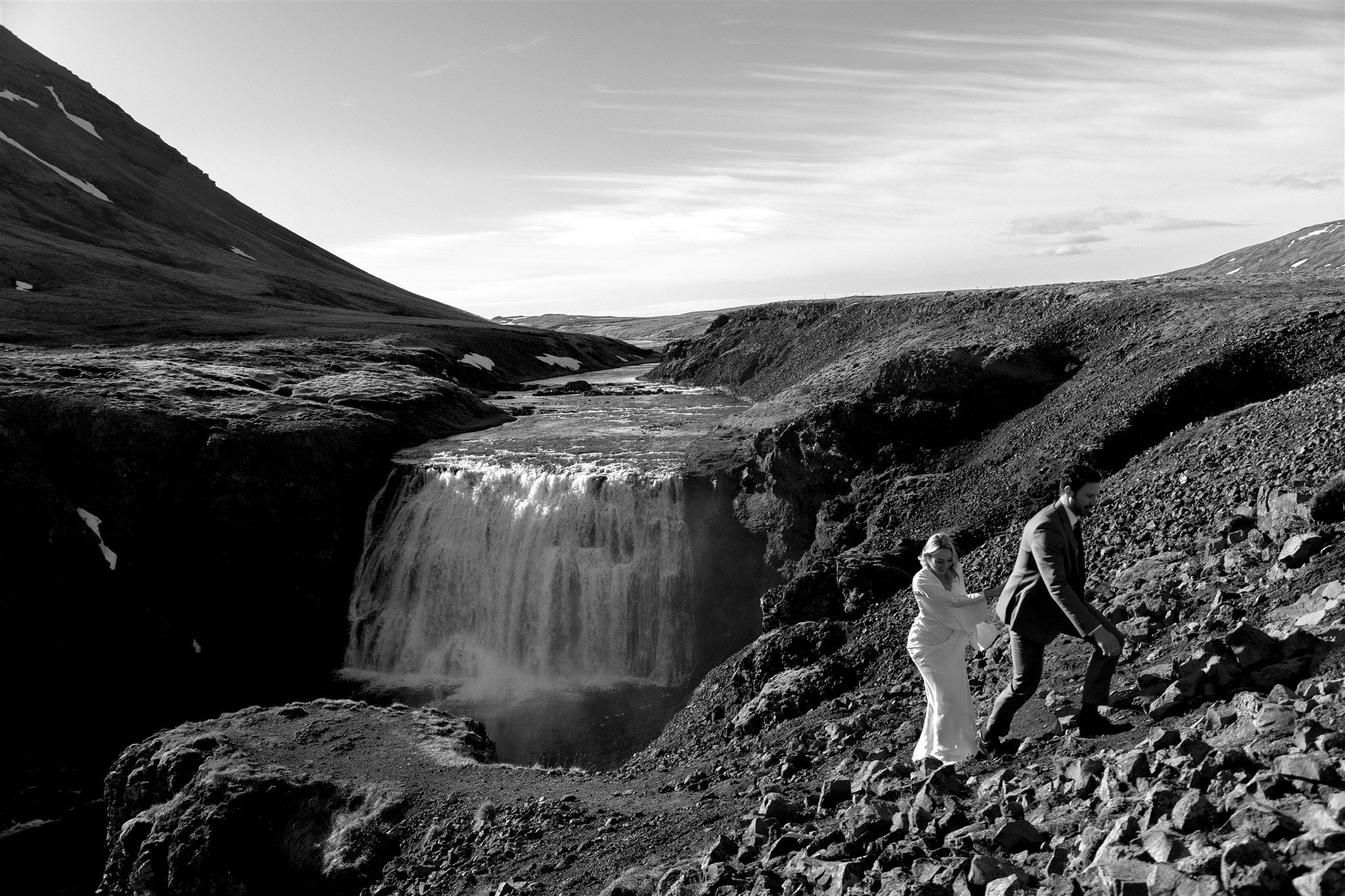 Lord of the Rings Inspired Iceland Engagement Photoshoot at waterfall — couple walking with Arwen inspired dress