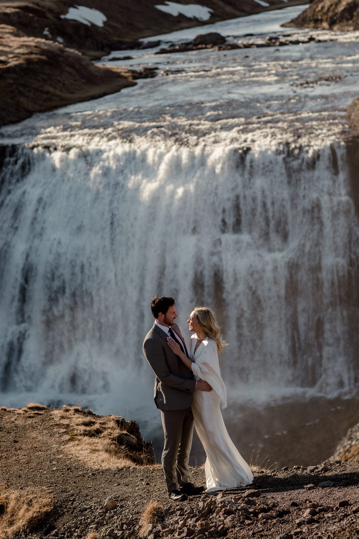 Lord of the Rings Inspired Iceland Engagement Photoshoot at waterfall — couple walking with Arwen inspired dress