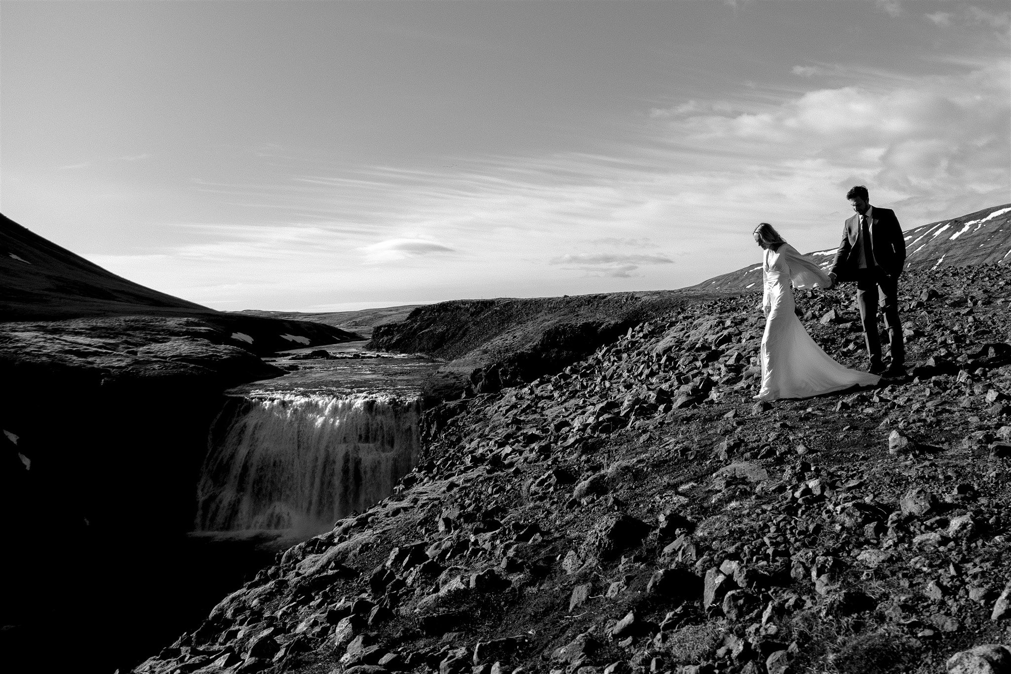 Lord of the Rings Inspired Iceland Engagement Photoshoot at waterfall — couple walking with Arwen inspired dress