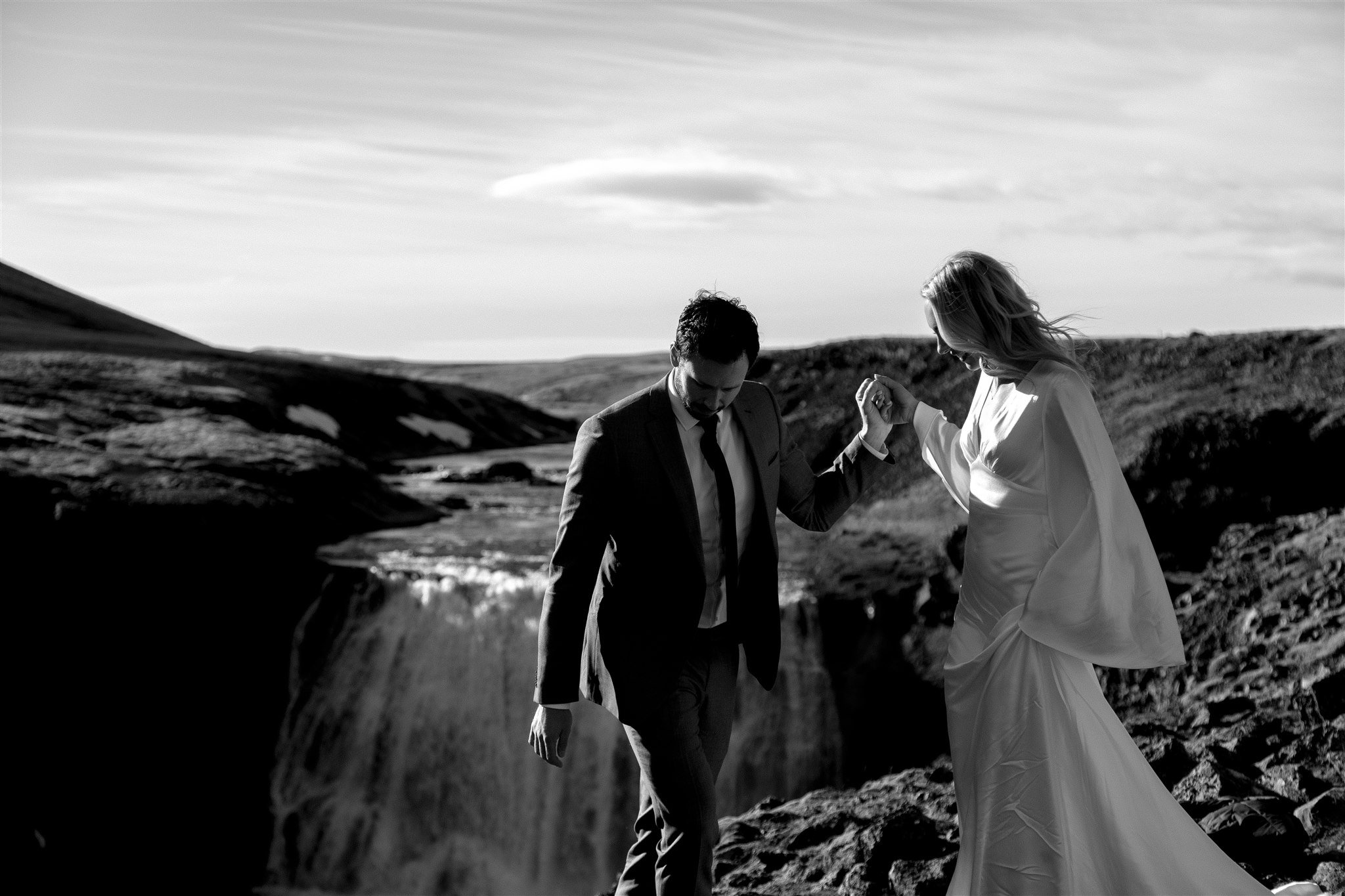 Lord of the Rings Inspired Iceland Engagement Photoshoot at waterfall — couple walking with Arwen inspired dress