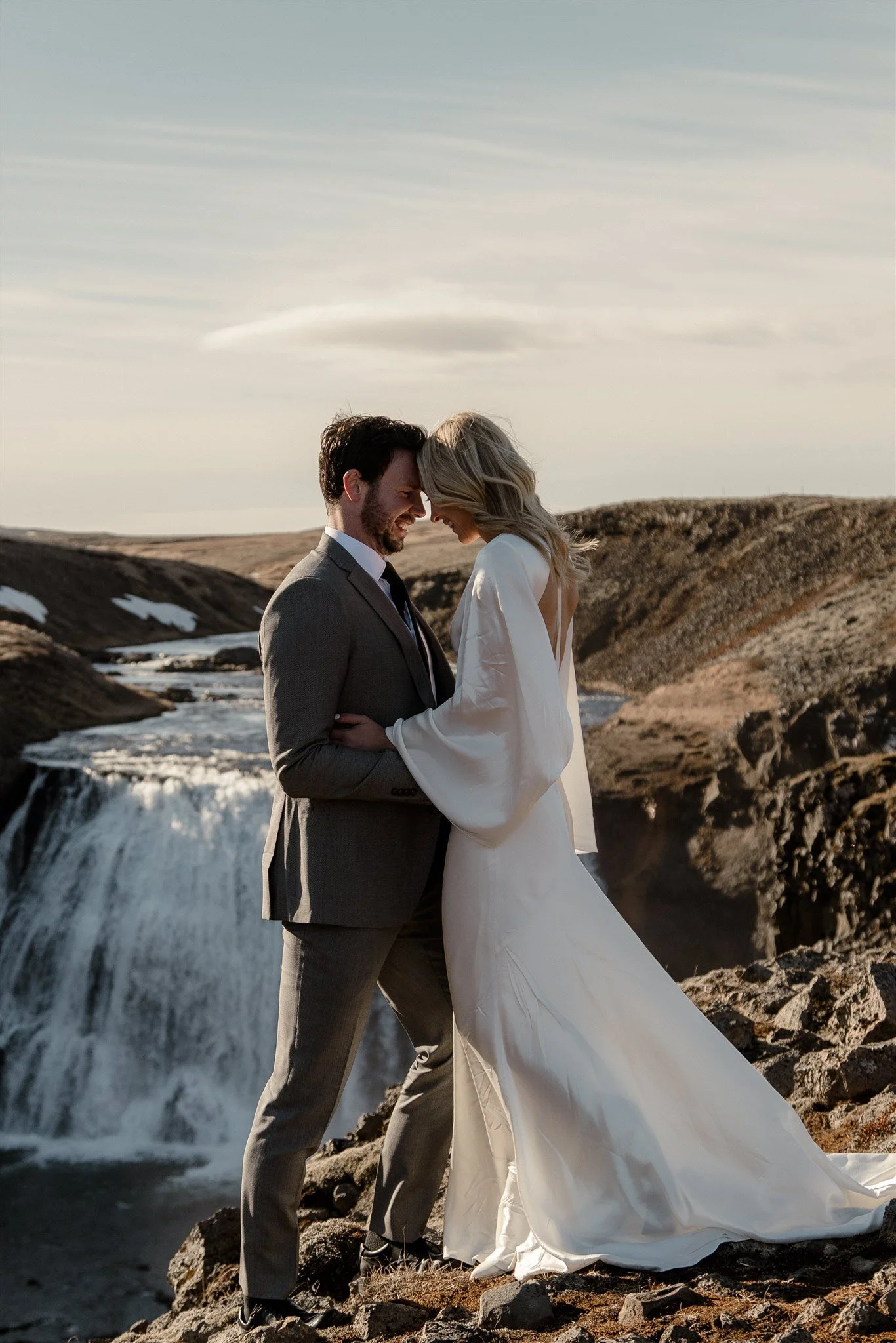Lord of the Rings Inspired Iceland Engagement Photoshoot at waterfall — couple together with Arwen inspired dress