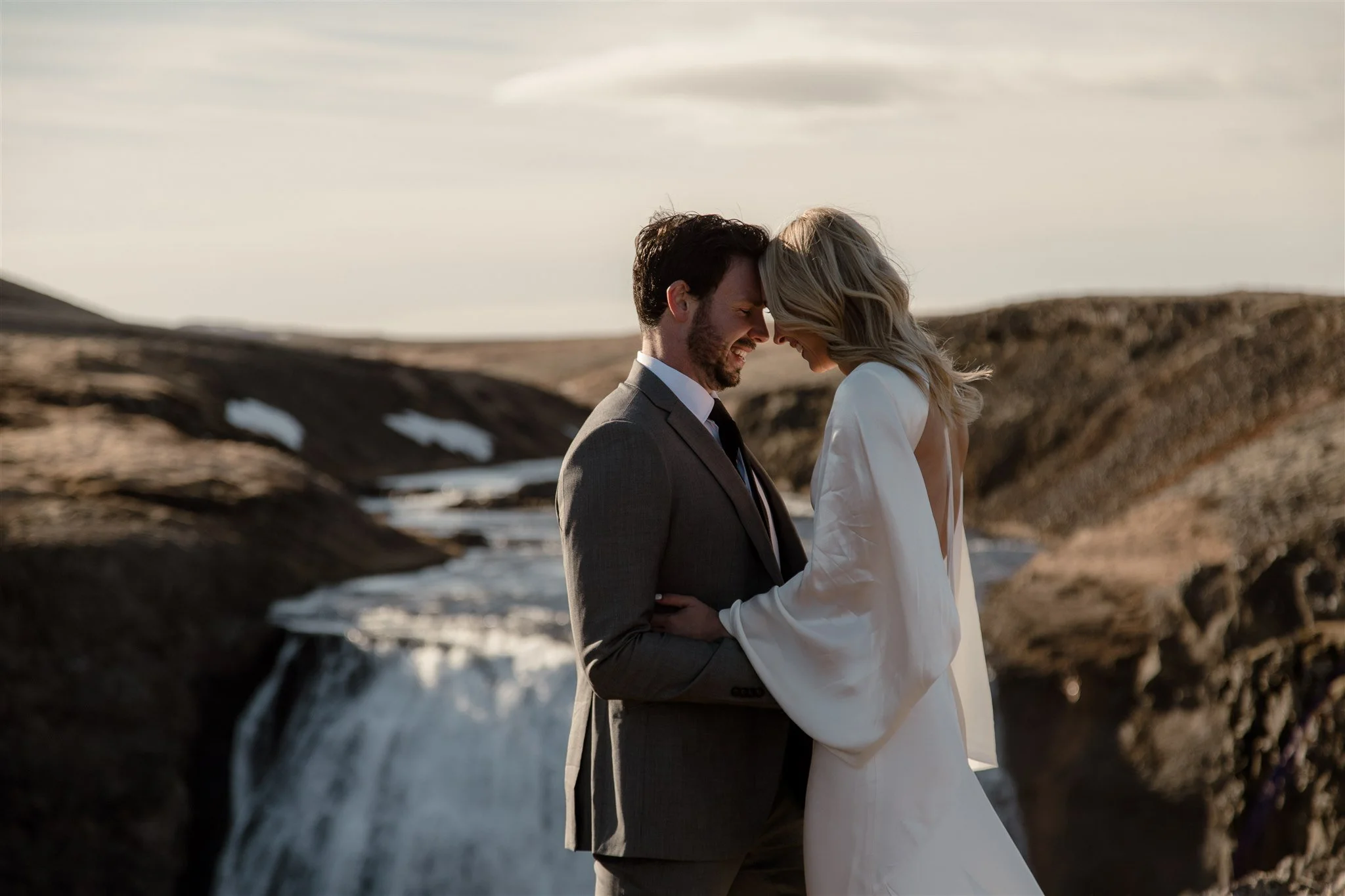 Lord of the Rings Inspired Iceland Engagement Photoshoot at waterfall — couple together with Arwen inspired dress