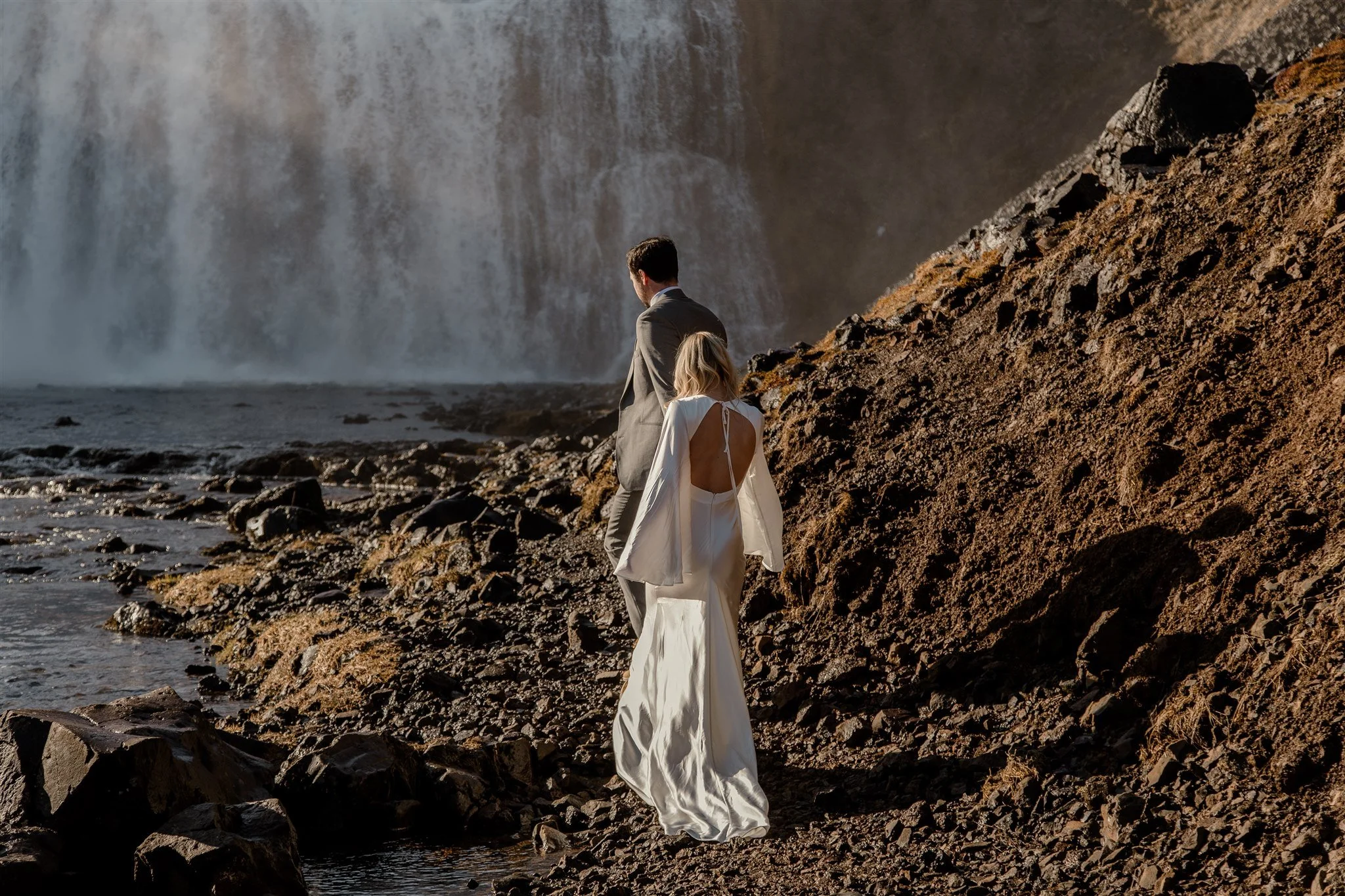 Lord of the Rings Inspired Iceland Engagement Photoshoot at waterfall — couple together with Arwen inspired dress