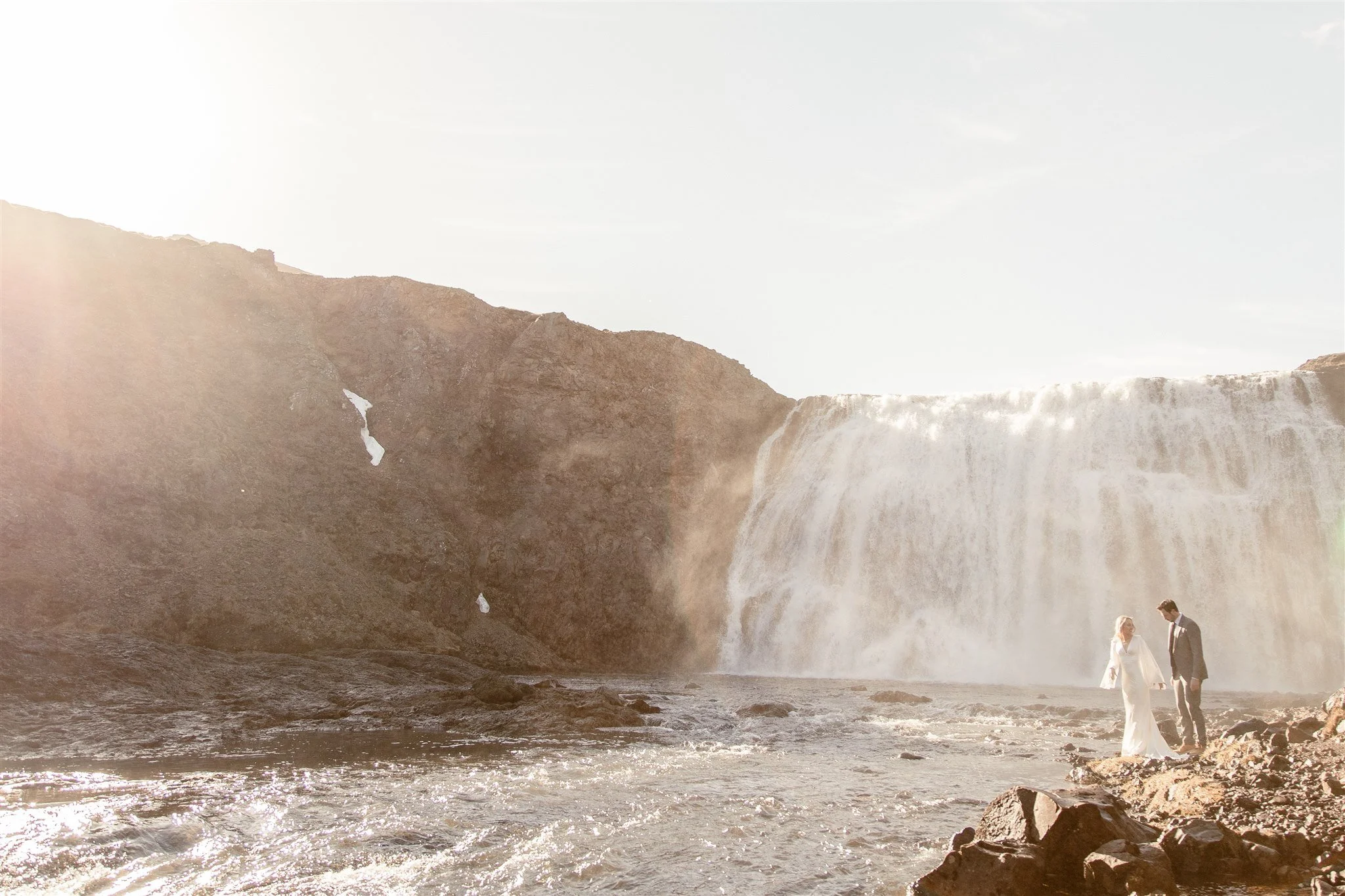 Lord of the Rings Inspired Iceland Engagement Photoshoot at waterfall — couple standing together with Arwen inspired dress