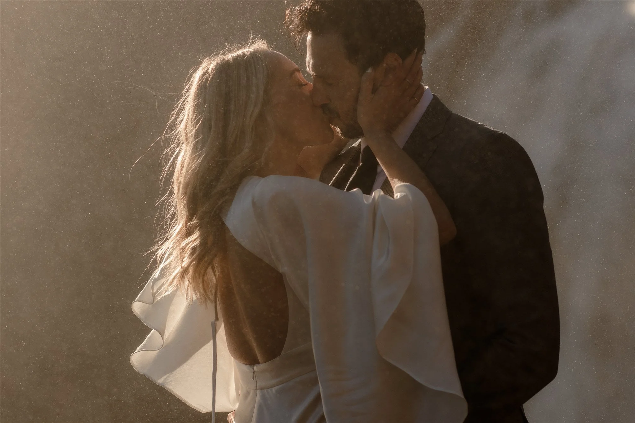 Lord of the Rings Inspired Iceland Engagement Photoshoot at waterfall — couple standing together with Arwen inspired dress with beautiful light and waterfall mist