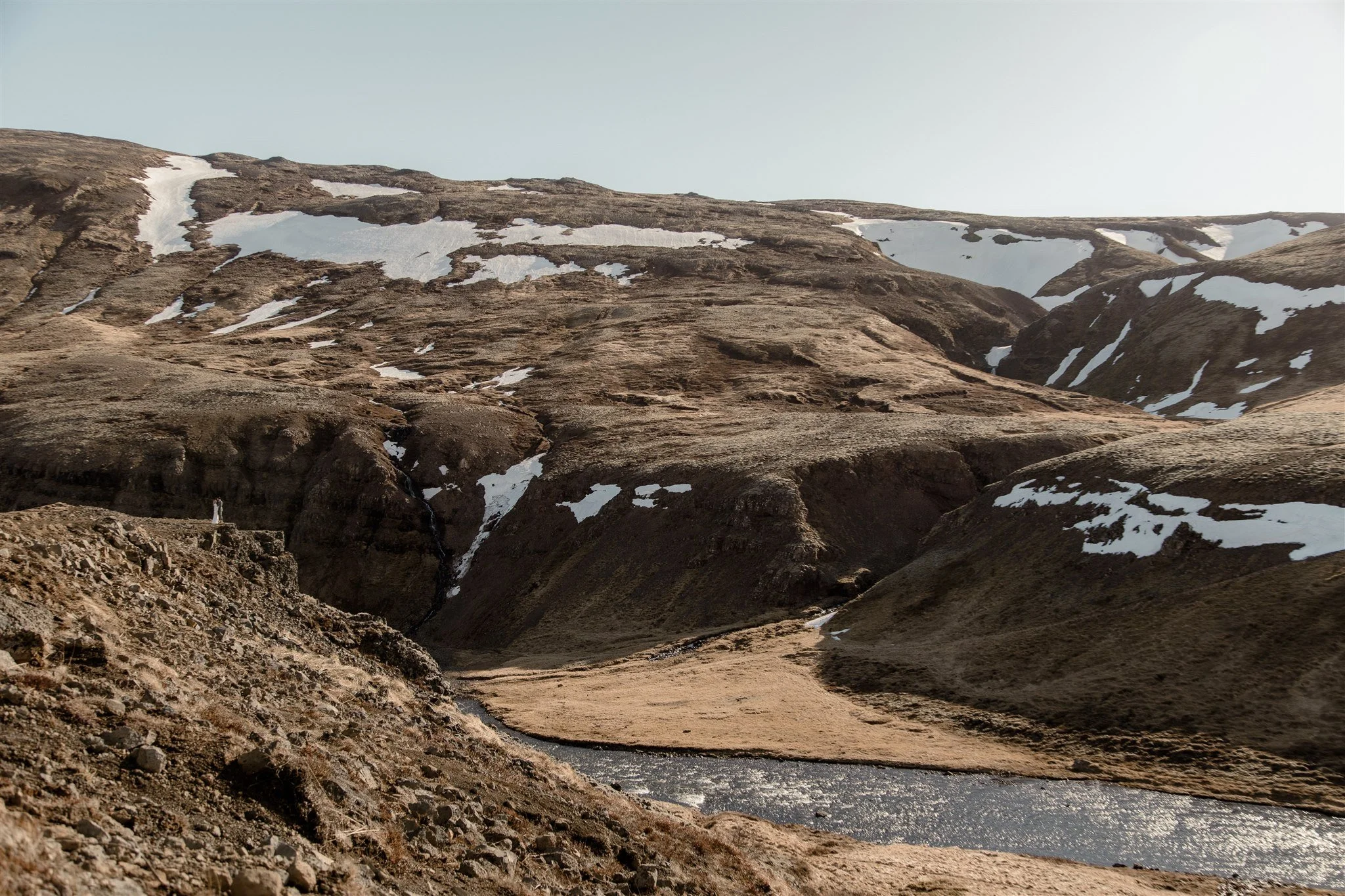 Lord of the Rings Inspired Iceland Engagement Photoshoot at waterfall — couple standing together on cliffs with Arwen inspired dress 