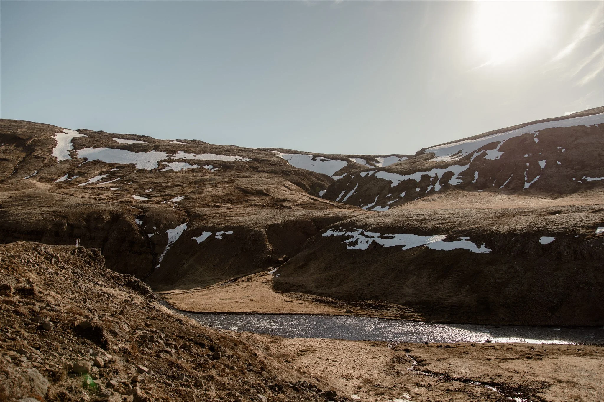 Lord of the Rings Inspired Iceland Engagement Photoshoot at waterfall — couple standing together on cliffs with Arwen inspired dress 