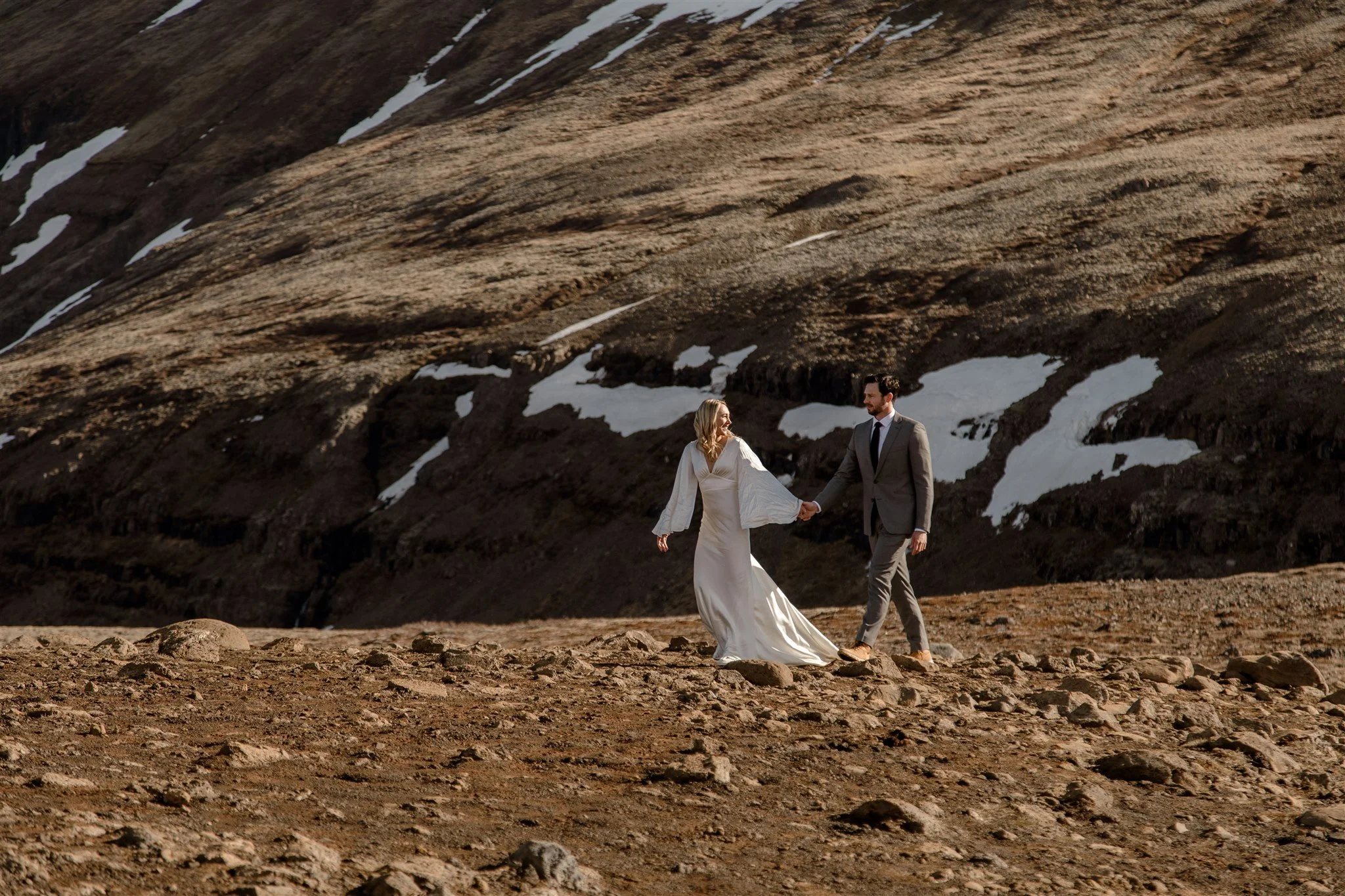 Lord of the Rings Inspired Iceland Engagement Photoshoot at waterfall — couple standing together on cliffs with Arwen inspired dress 