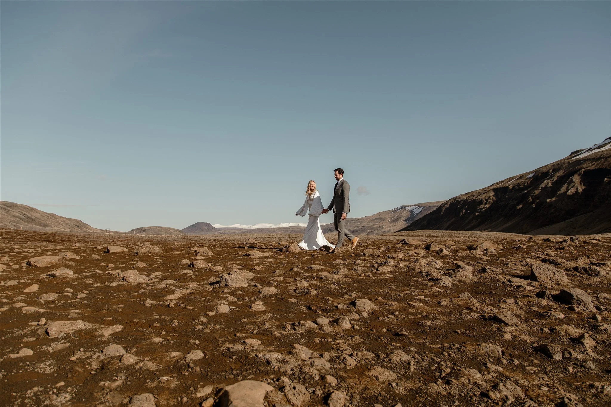 Lord of the Rings Inspired Iceland Engagement Photoshoot at waterfall — couple walking together with Arwen inspired dress 