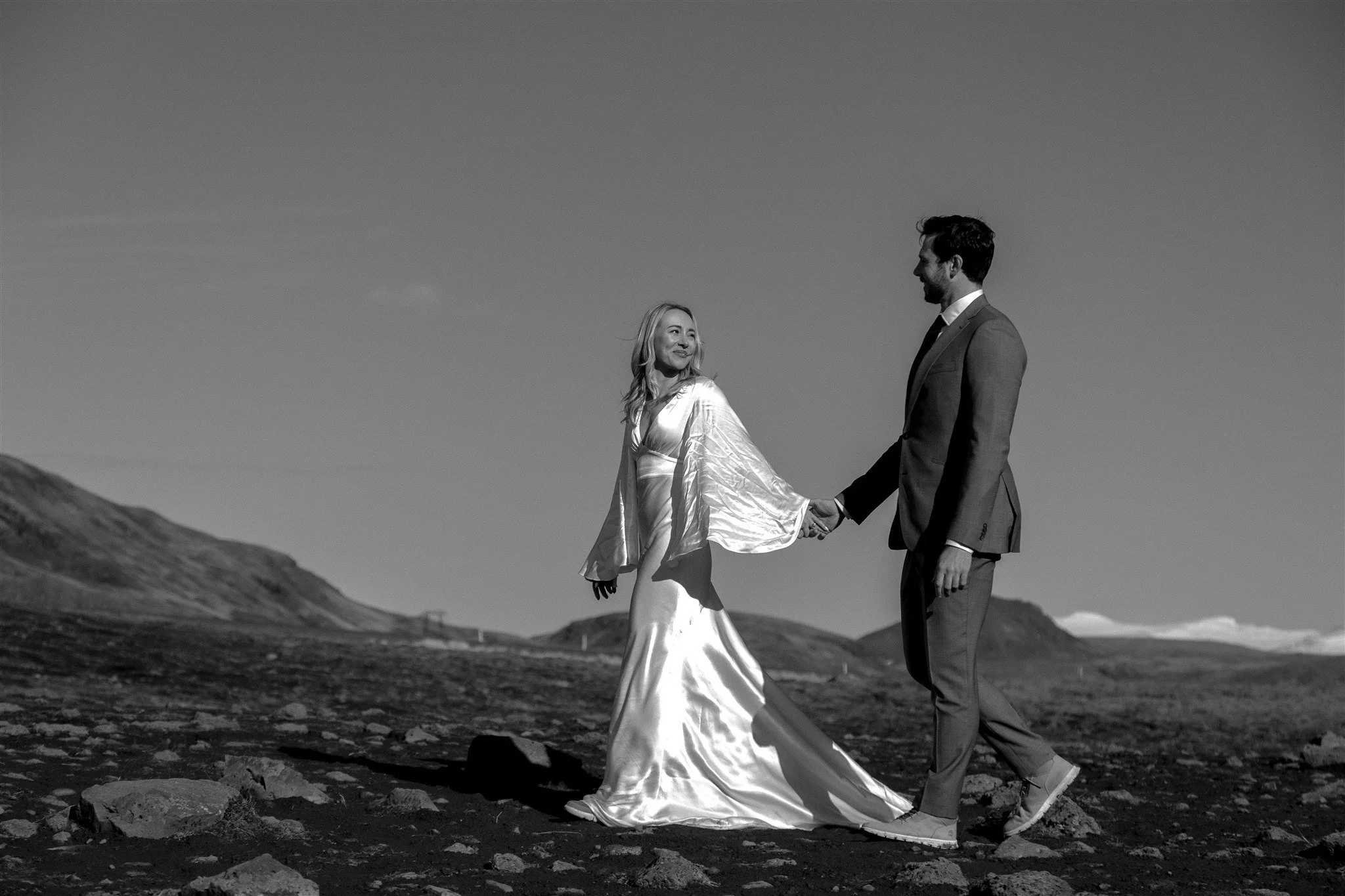 Lord of the Rings Inspired Iceland Engagement Photoshoot at waterfall — couple walking together with Arwen inspired dress 