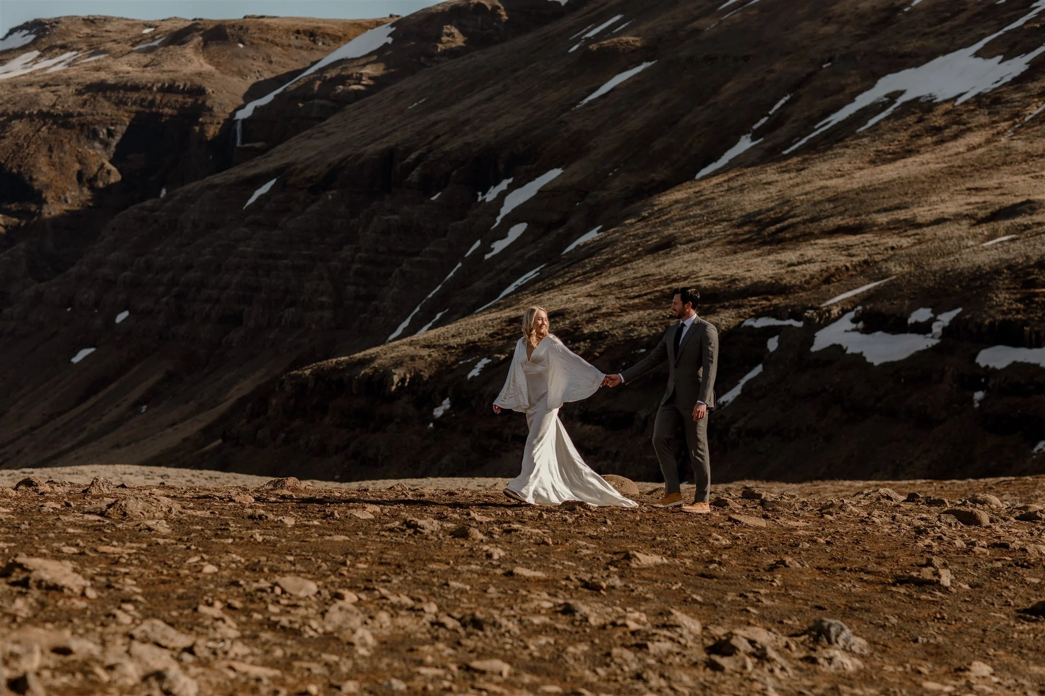 Lord of the Rings Inspired Iceland Engagement Photoshoot at waterfall — couple walking together with Arwen inspired dress 