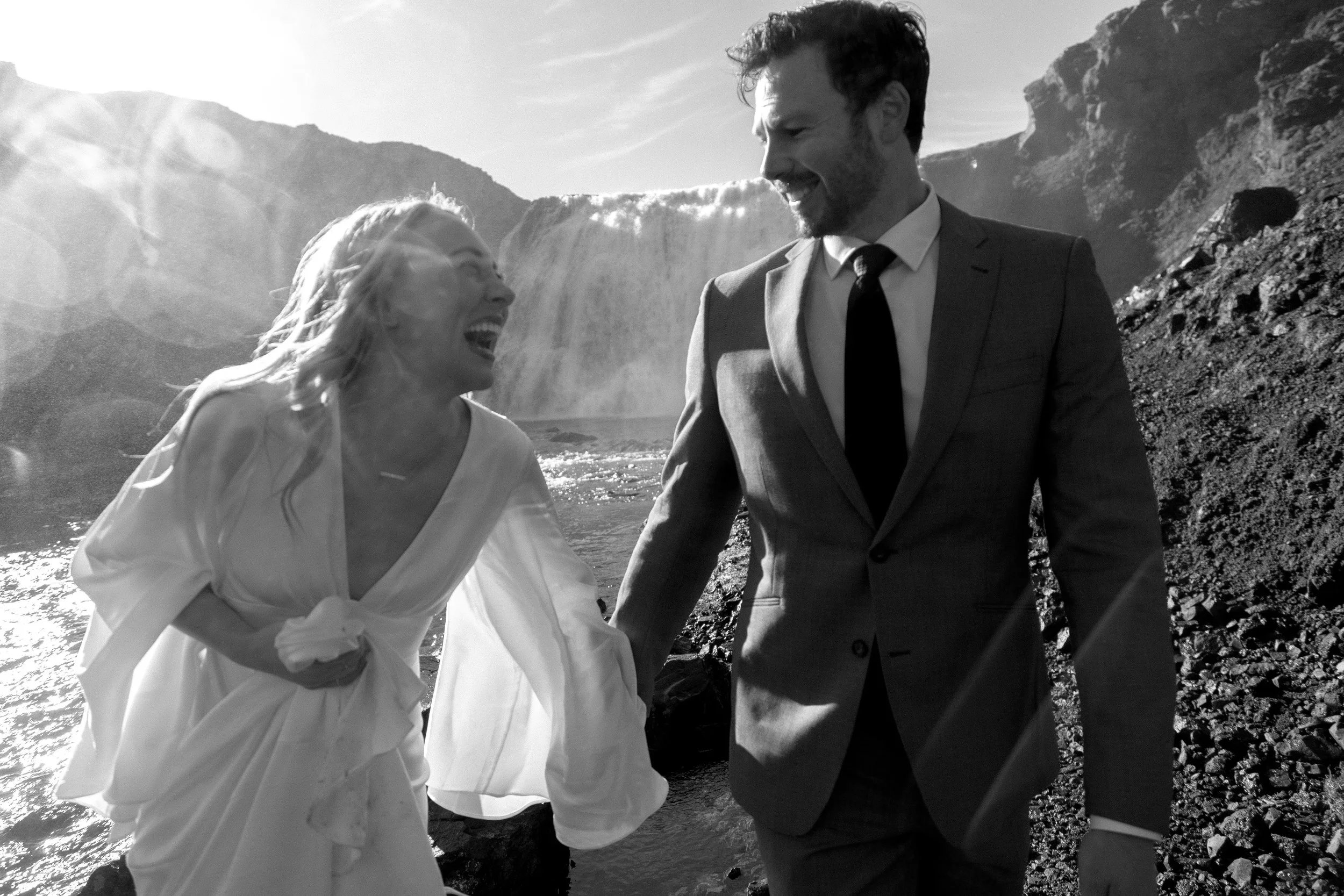 Iceland elopement candid photo at private waterfall bride laughing