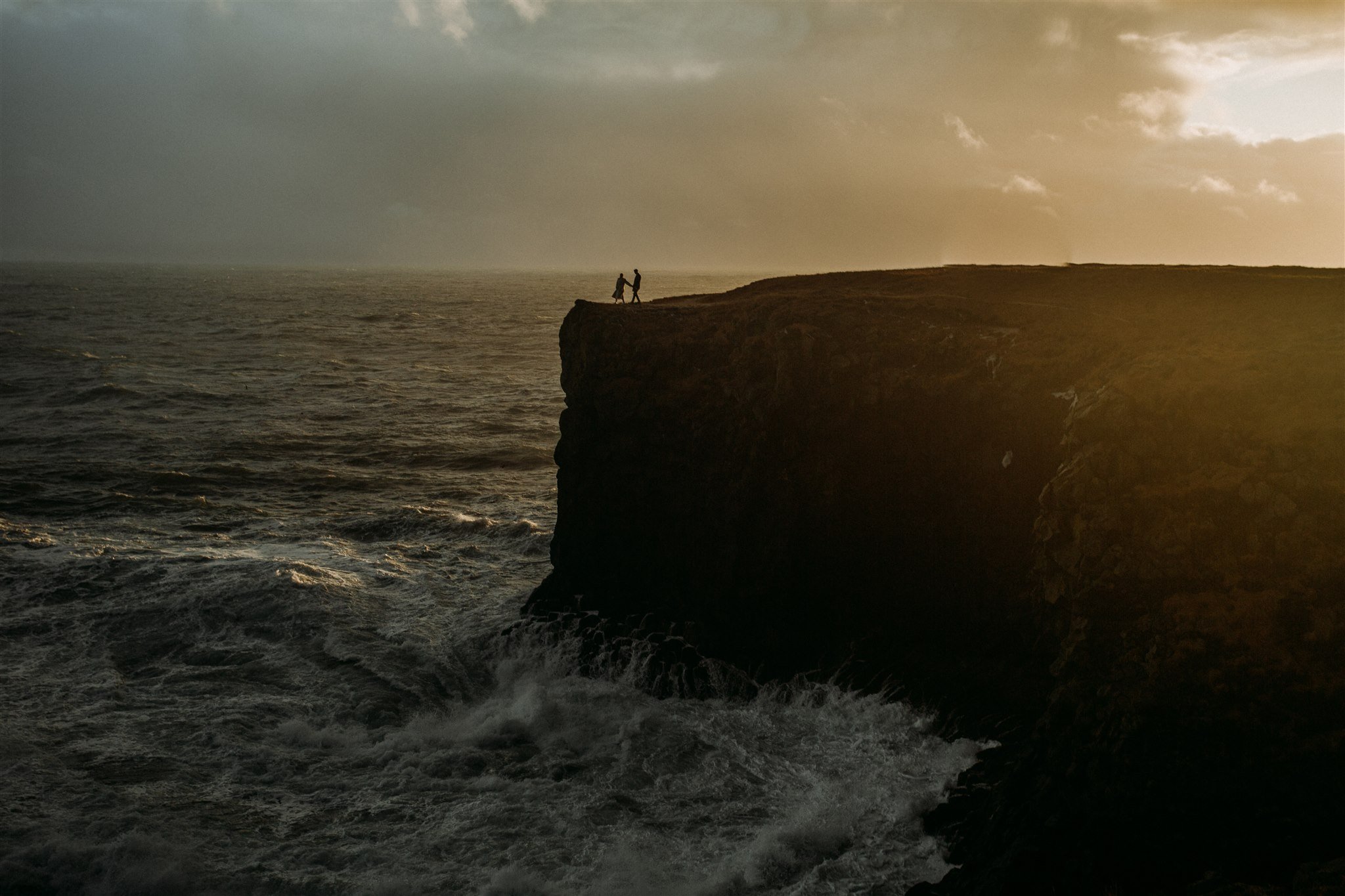 Iceland elopement on sea cliff with sea mist on lens